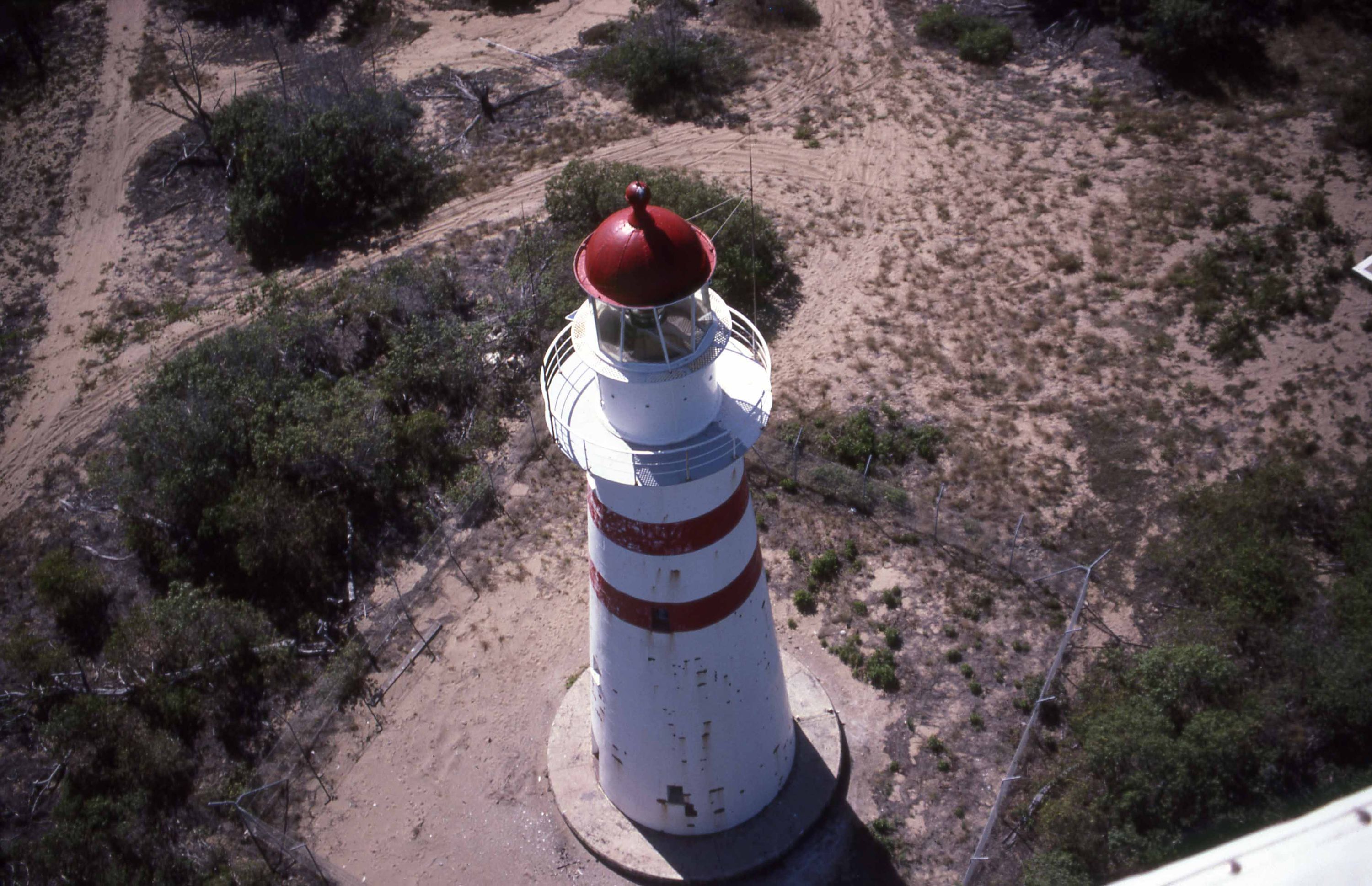 An aerial view of Cape Bowling Green Lighthouse showing the top of the lighthouse which is painted red