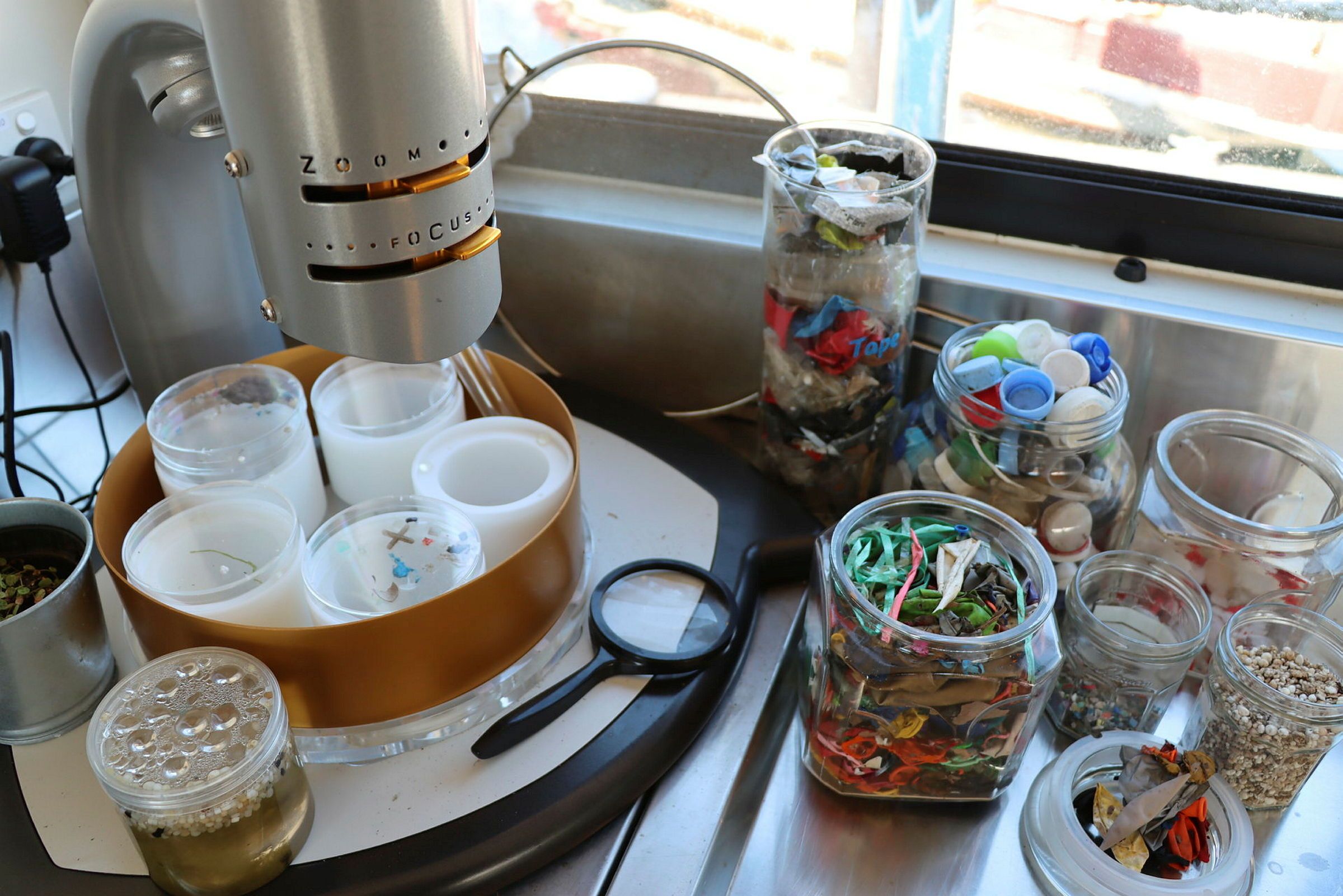 microscope and jars containing various objects, such as water, bottle caps andsmall plastic objects