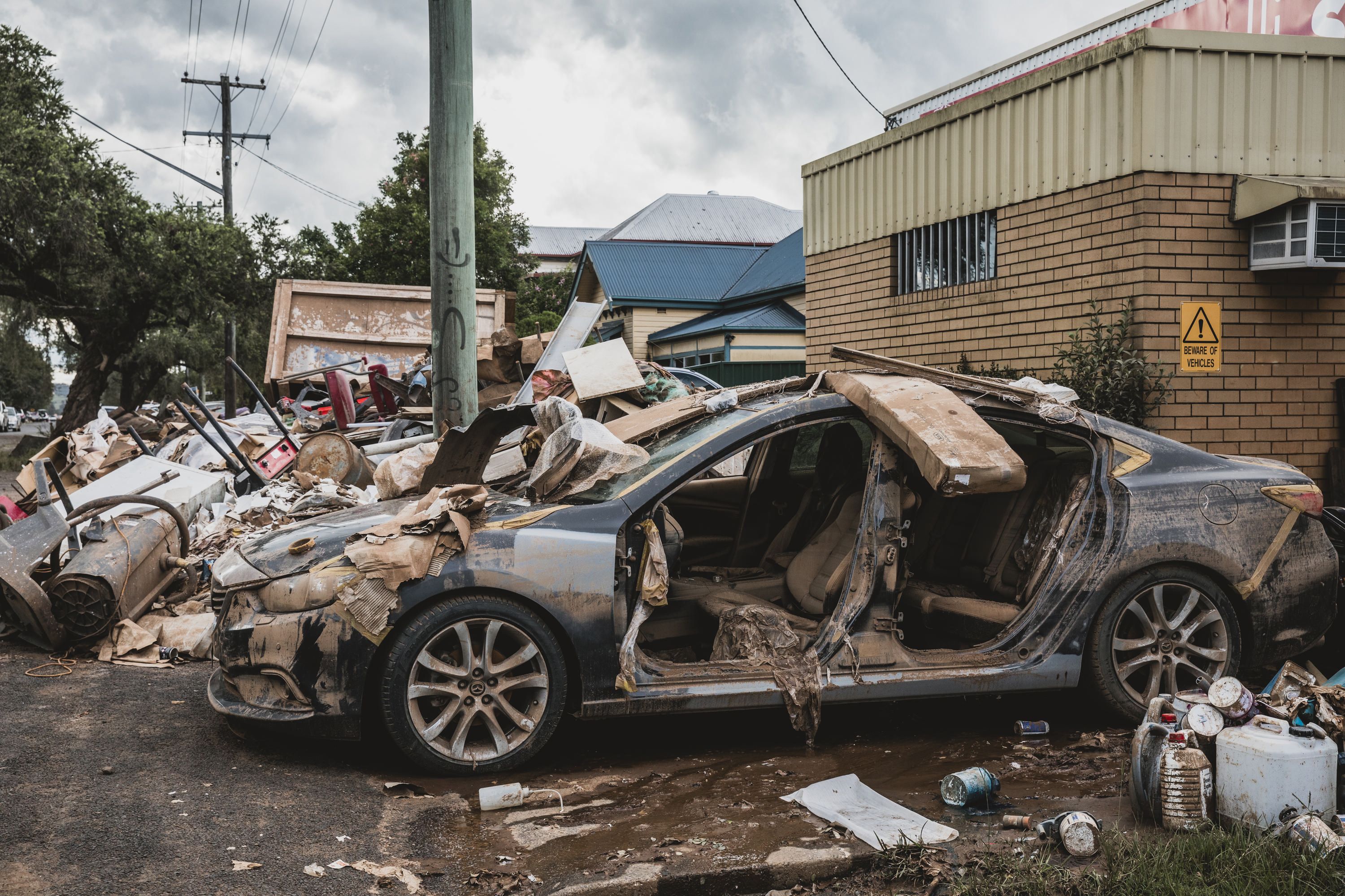 Photo of a car destroyed and surrounded by debris.