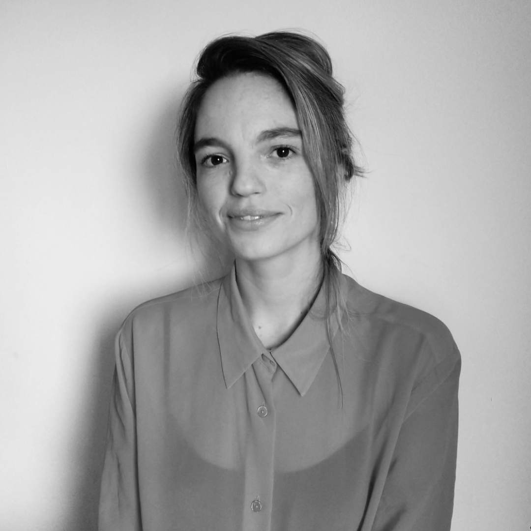 Black and white photo of a woman with her hair up and wearing a button up shirt