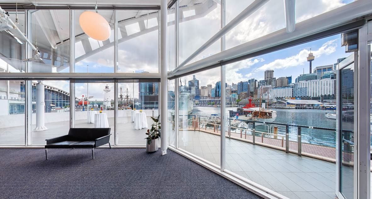 photo showing a wall of windows with a balcony and the harbour beyond. 