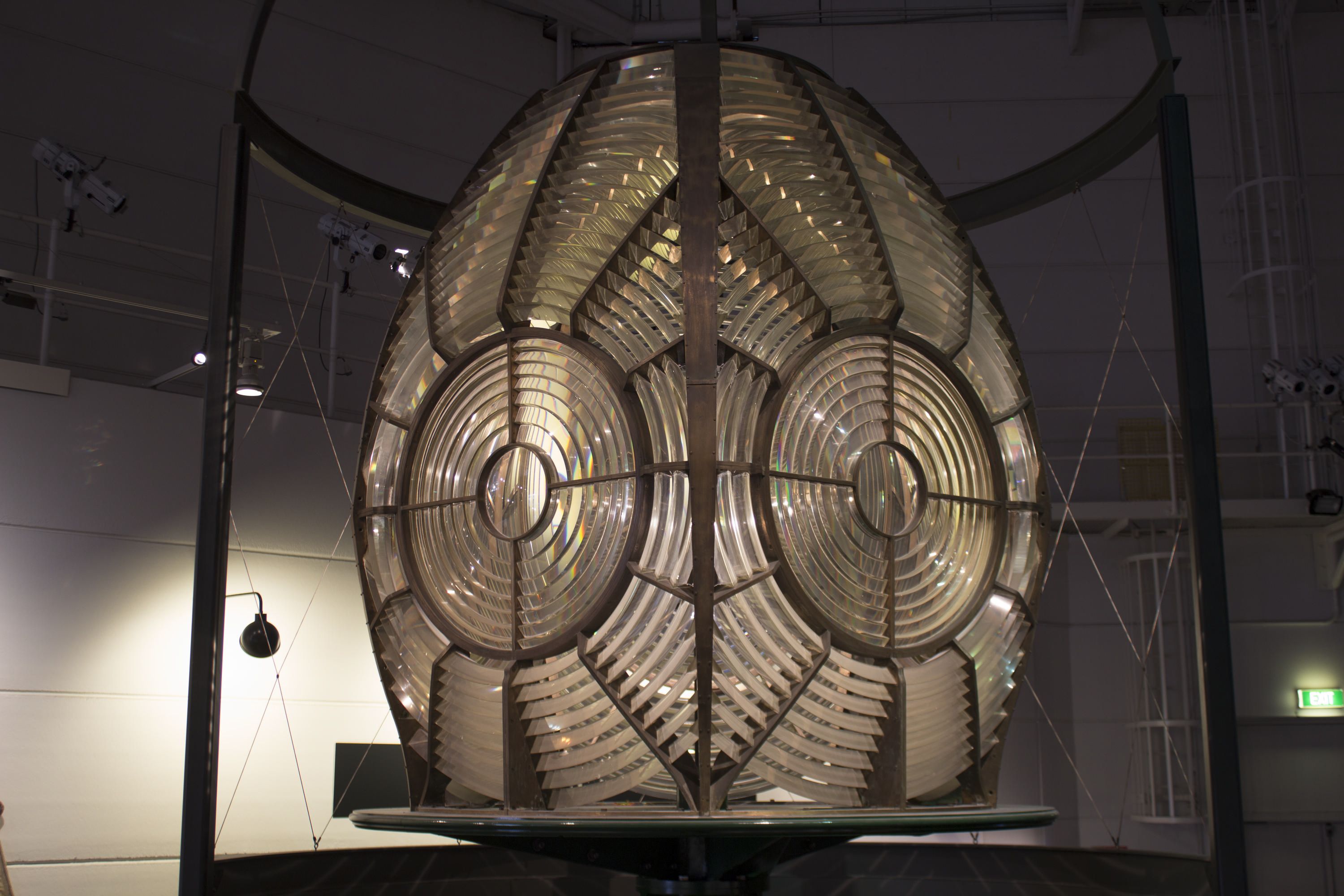 Photograph showing a historic lighthouse lense inside a museum exhibit