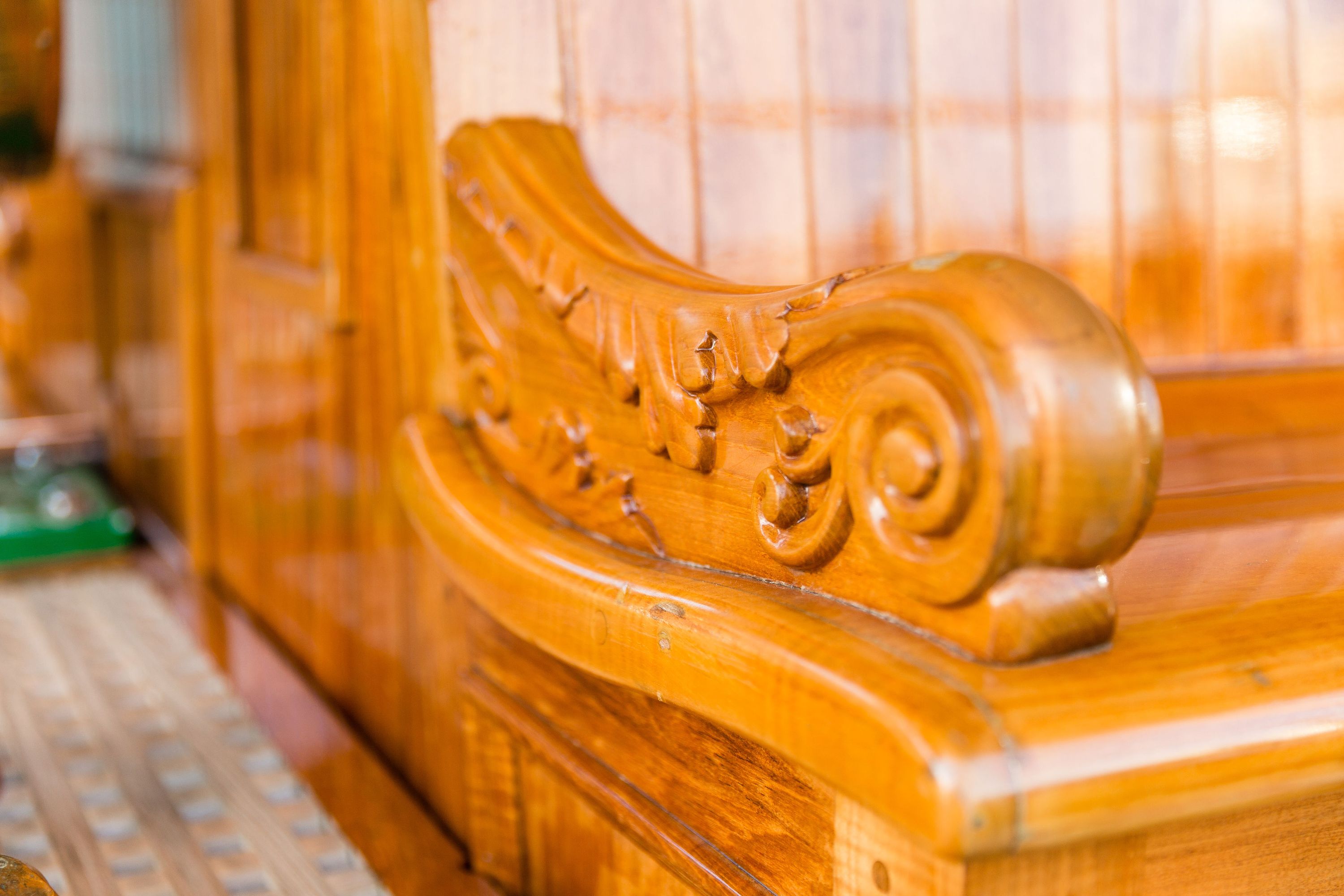 A detail photograph of the carved timber seat arm.