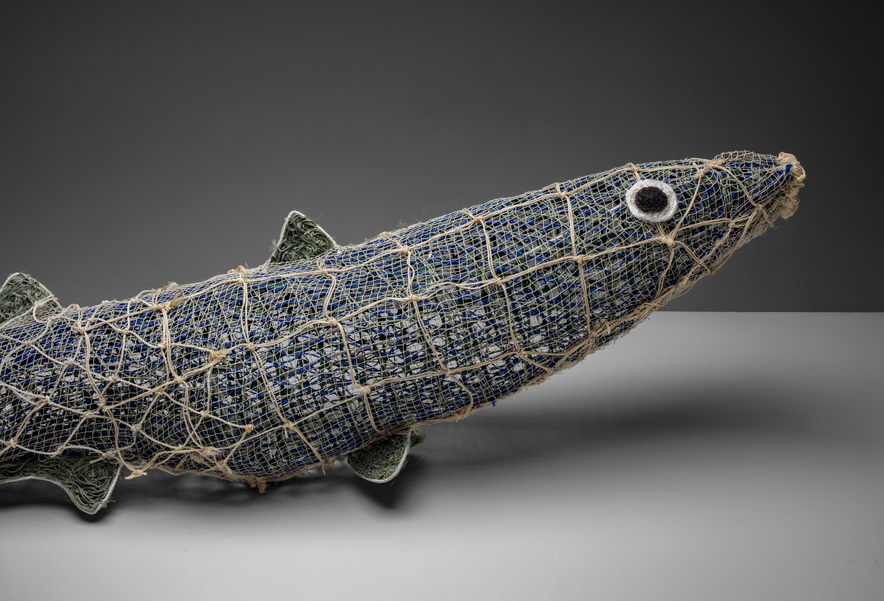 A black ghost net fish sculpture which resembles a mullet.