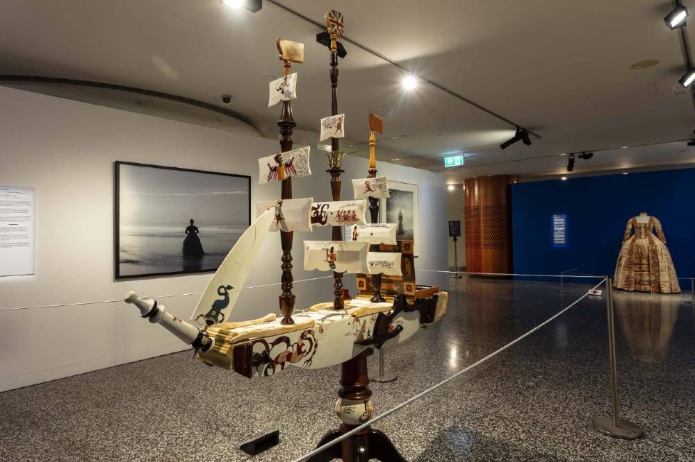 Photo showing an sculpture depicting a sailing ship in a museum exhibition.