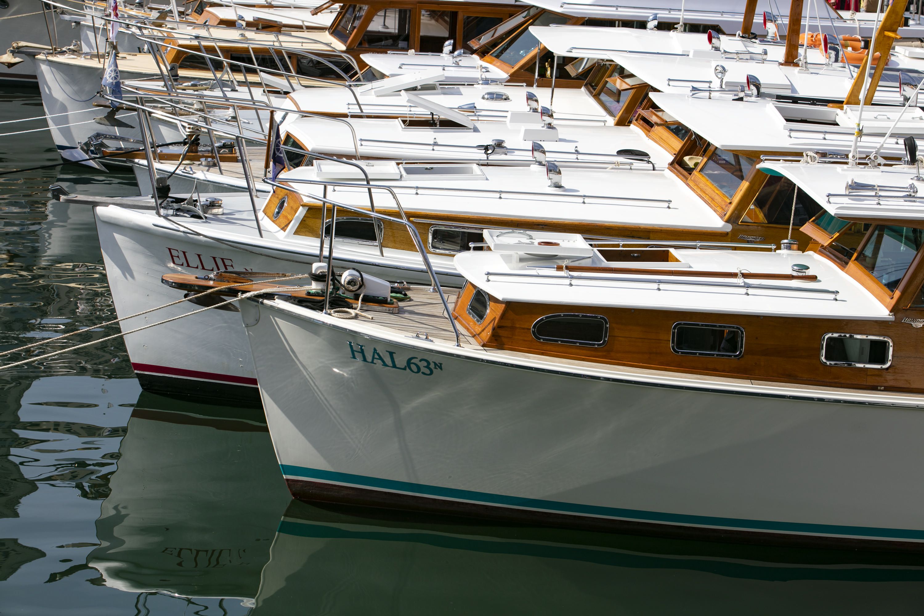 Photo showing wooden boats with white paint moored in a line 