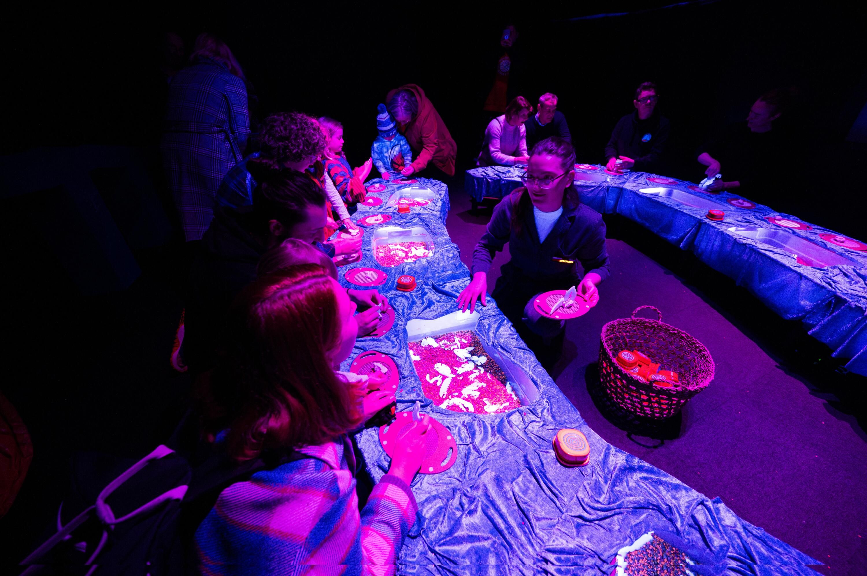 People sitting around a table under neon lights