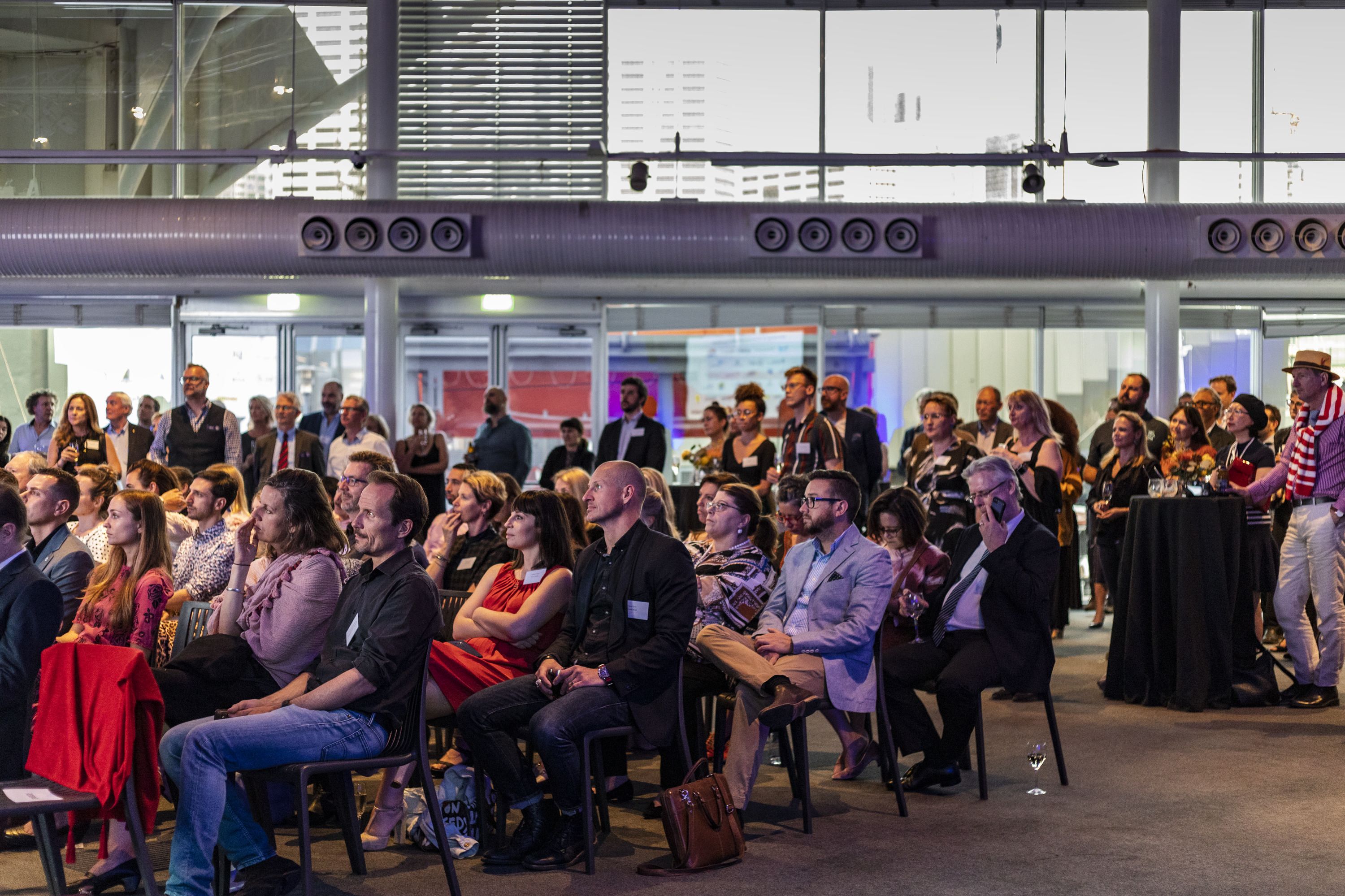 Audience of event guests listening to event speeches.