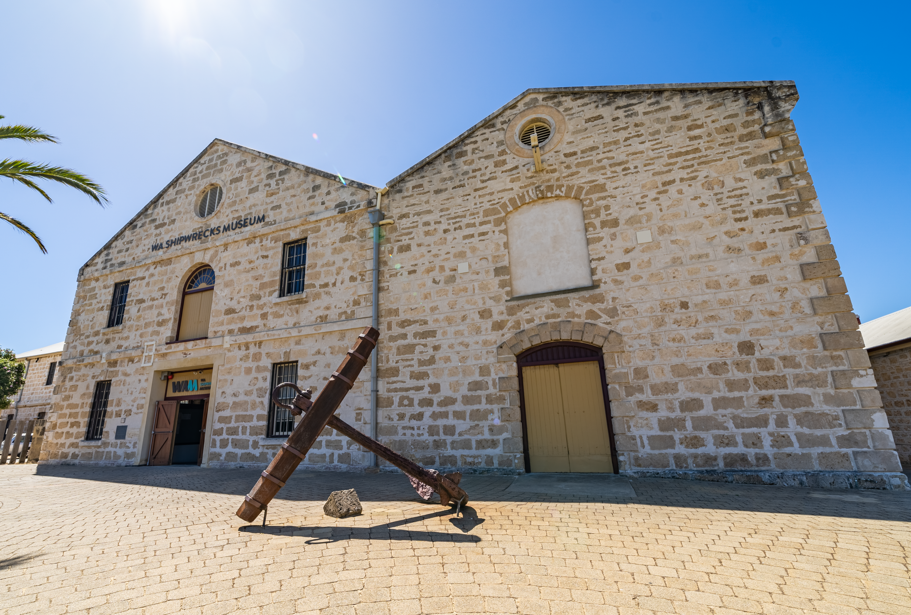 Photo of a stone building with an anchor in front.