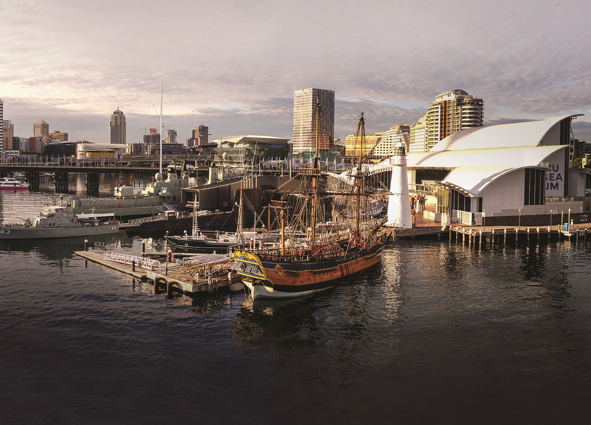 Aerial photograph showing the museum building, lighthouse and multiple ships in the harbour.
