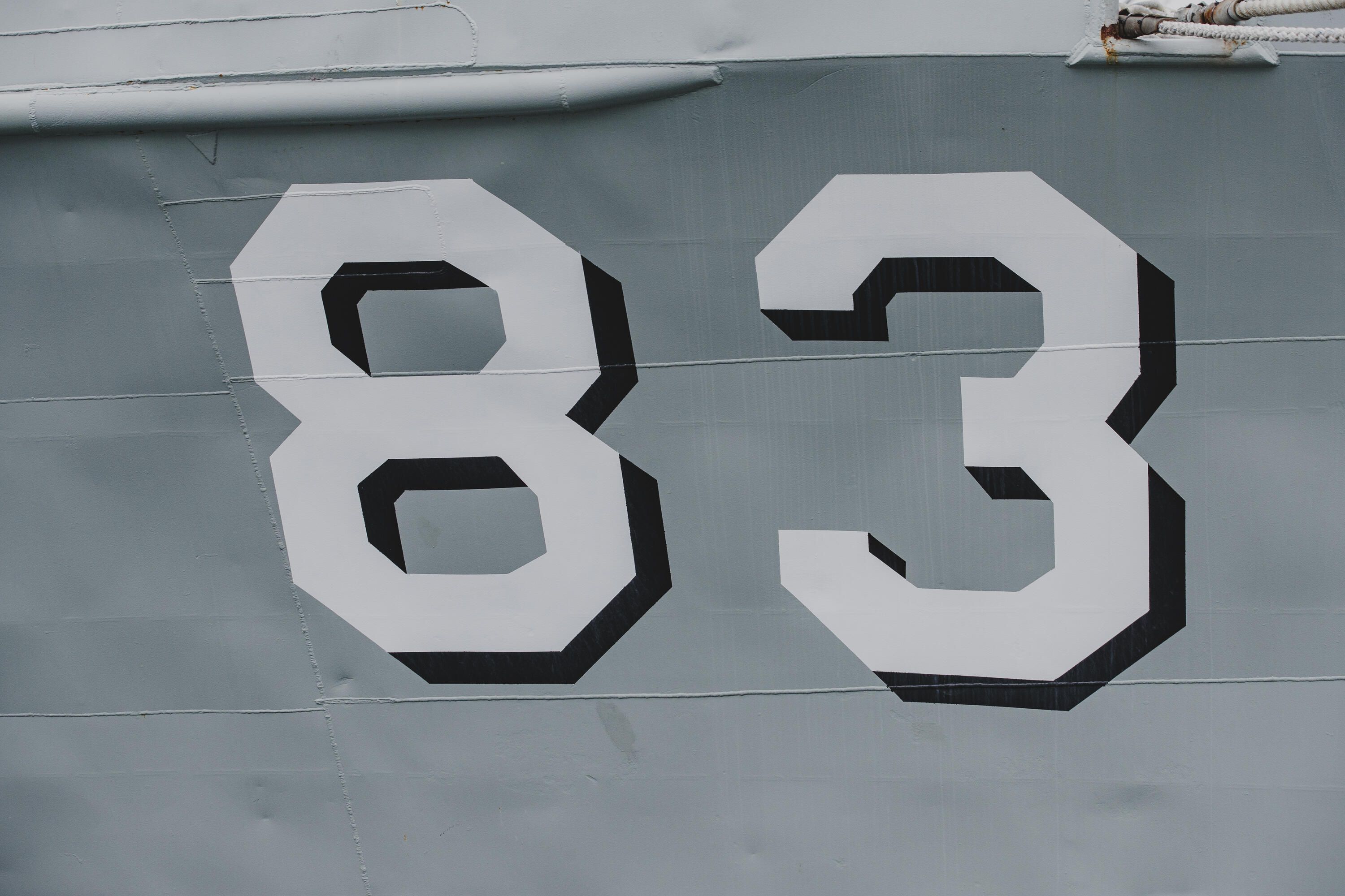 close up photo showing the number 83 painted on the side of a Navy ship.