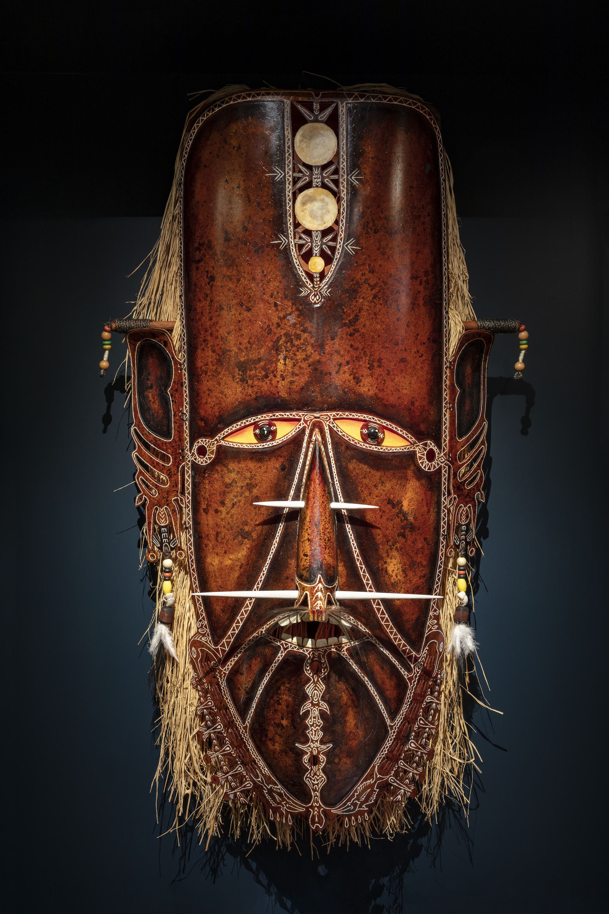 Large fibreglass mask with raffia, pearl and shell ornaments made by artist Alick Tipoti.