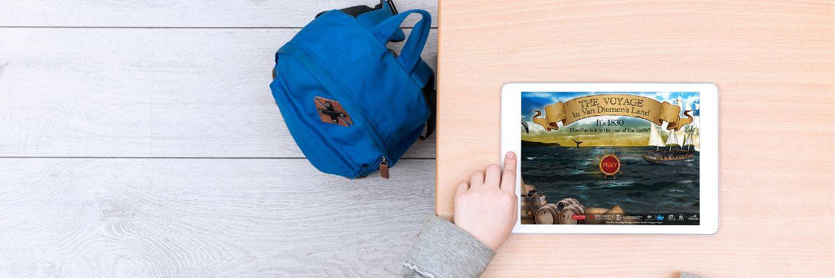 Photo taken looking down at an iPad on a table playing the game Voyage Game