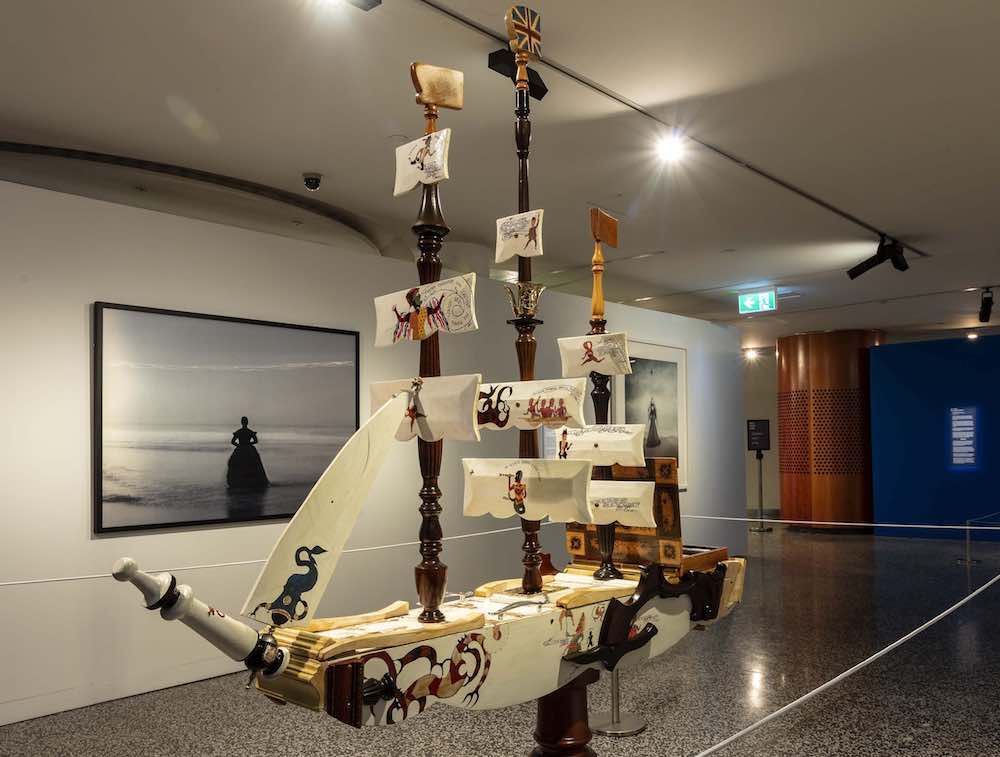 Photo showing an sculpture depicting a sailing ship in a museum exhibition.