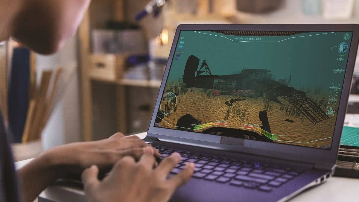 Laptop computer playing a game where theplayer is diving underwater looking at a shipwreck.