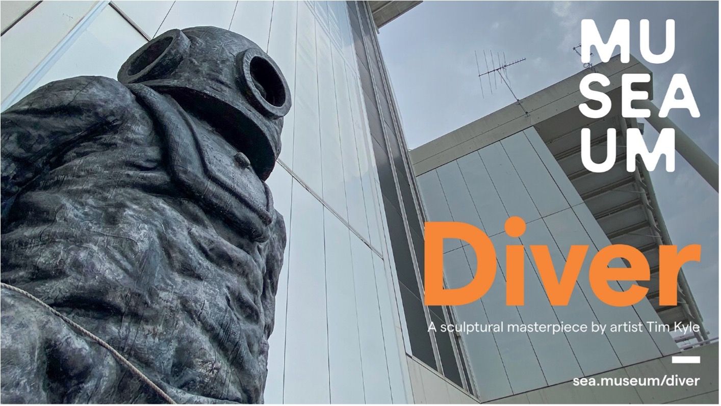Photo looking up at a sculpture of a diver