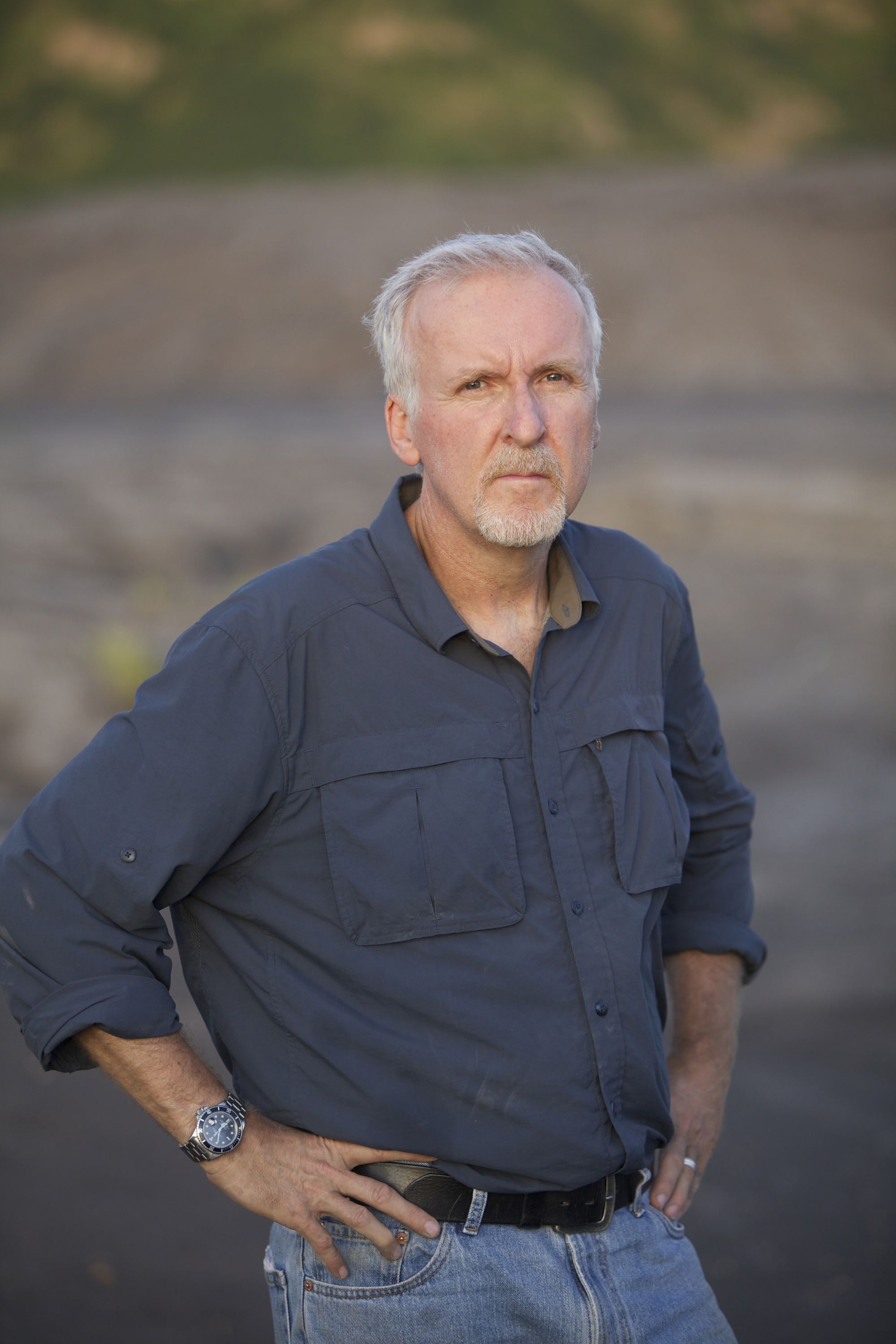 Photo of a man, James Cameron, wearing a blue button up shirt and jeans. 