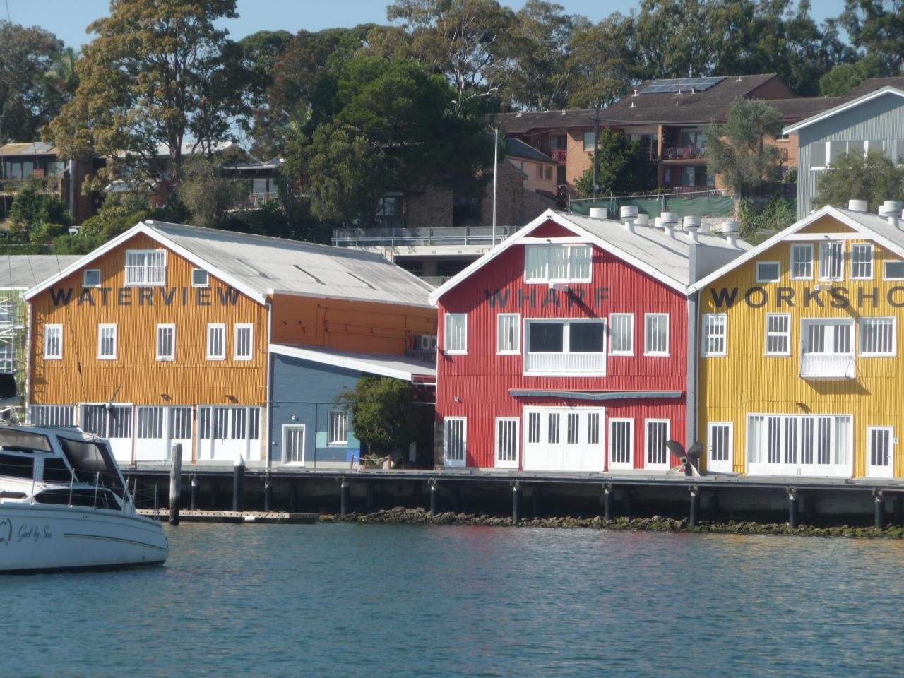 Photo showing 3, coloured buildings next to the water.