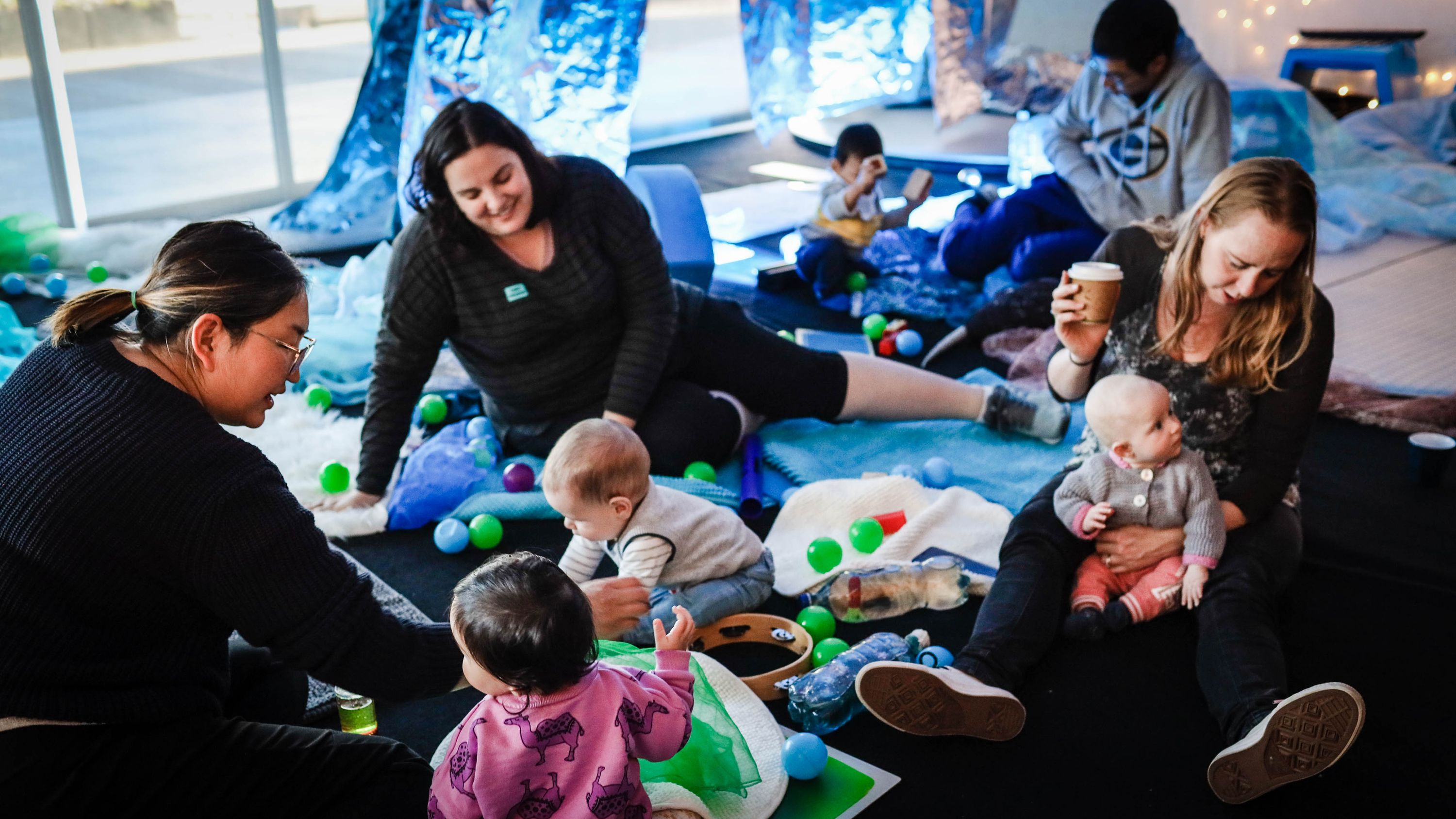 Parents and babies relaxing in the play space.