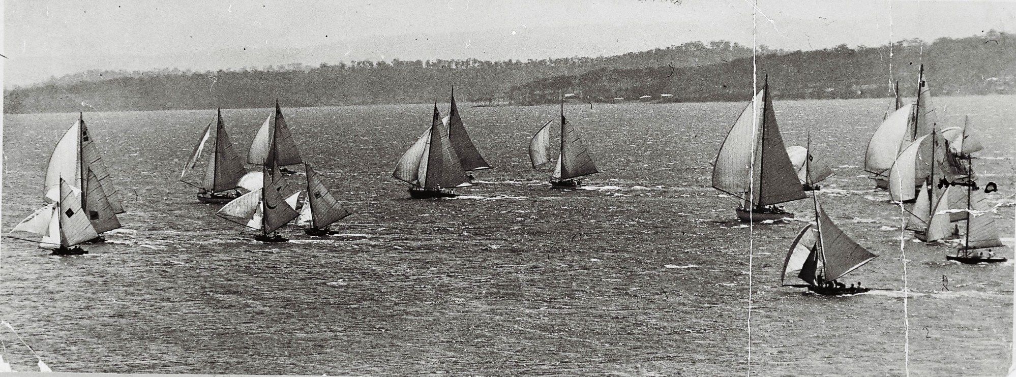 Black and White old photo showing many boats sailing.