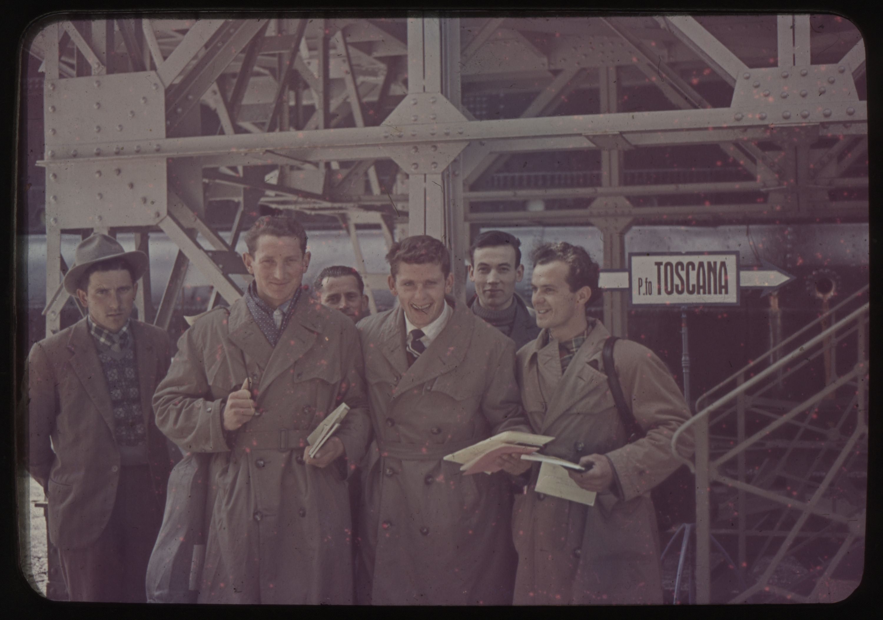 Six men next to a sign reading TOSCANA
