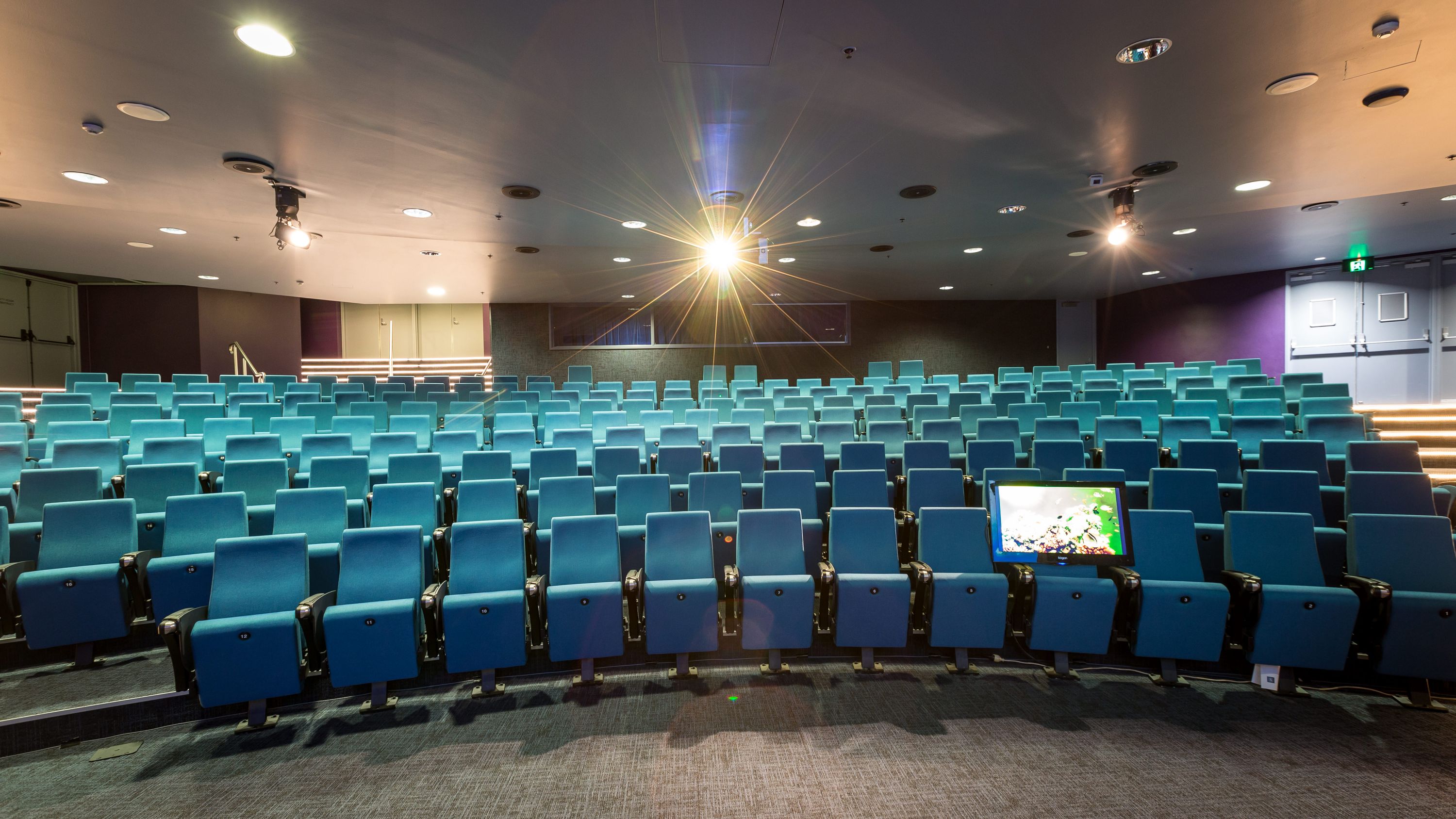 Photo of a theatre, showing many rows of chairs on a slope. 
