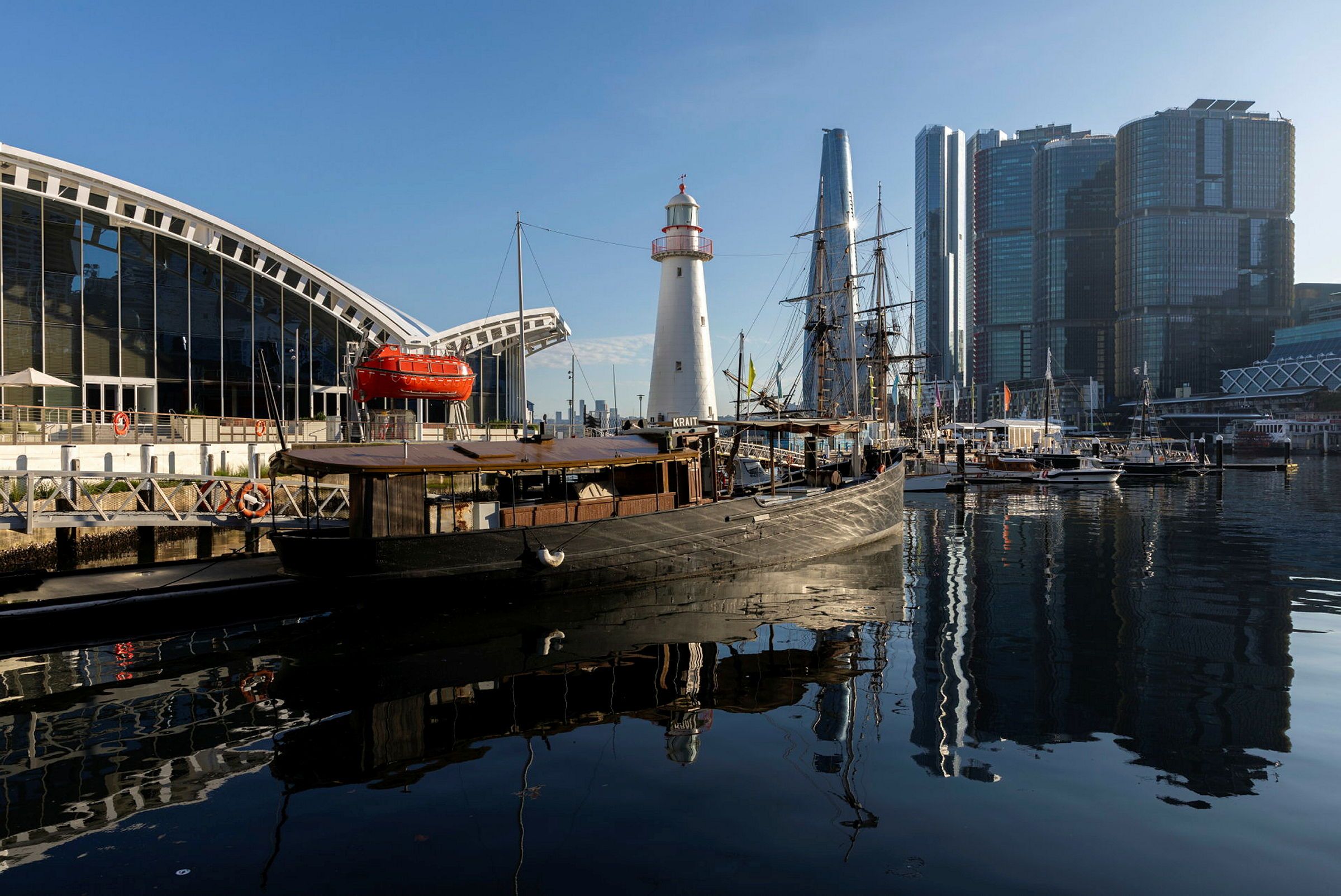 Photo of a black and brown boat at a wharf in the harbour.