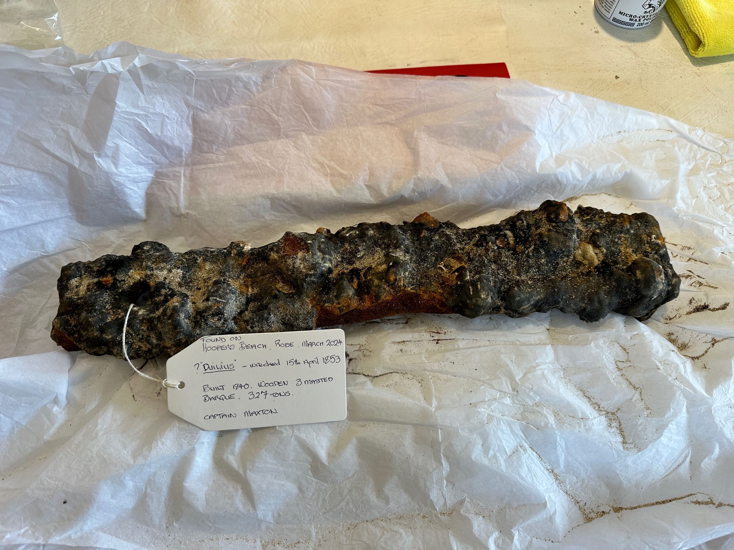 Photo of a long, metal object which has been heavily worn and corroded.
