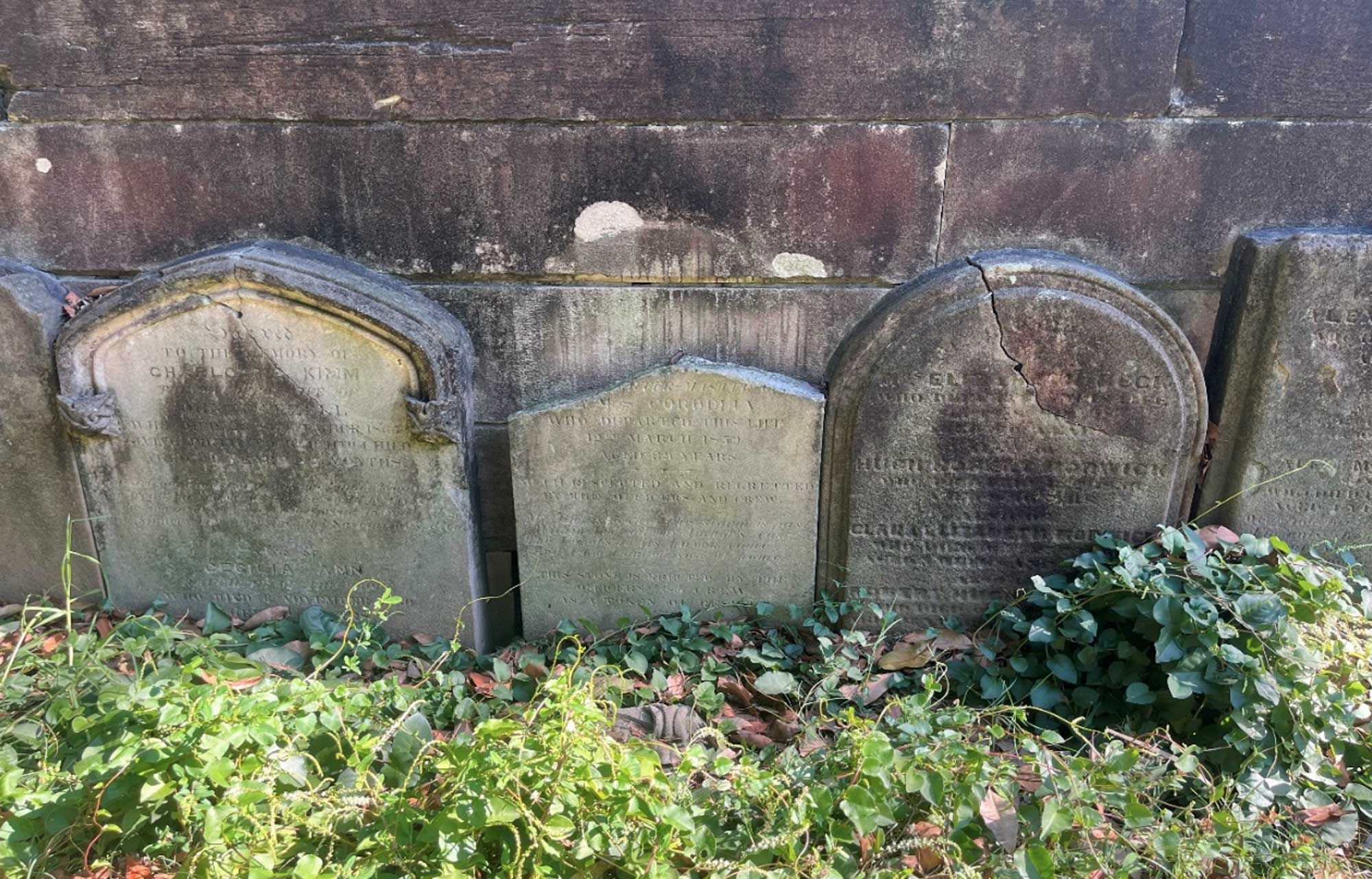 Photo of gravestones against a wall