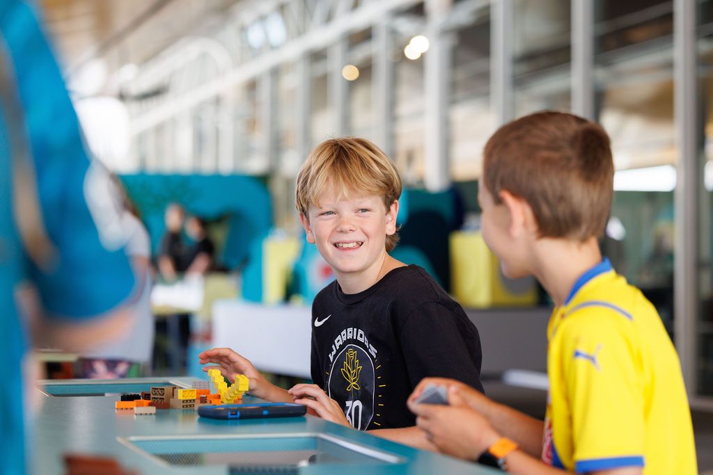 Photo of 2 boys smiling and building with Lego