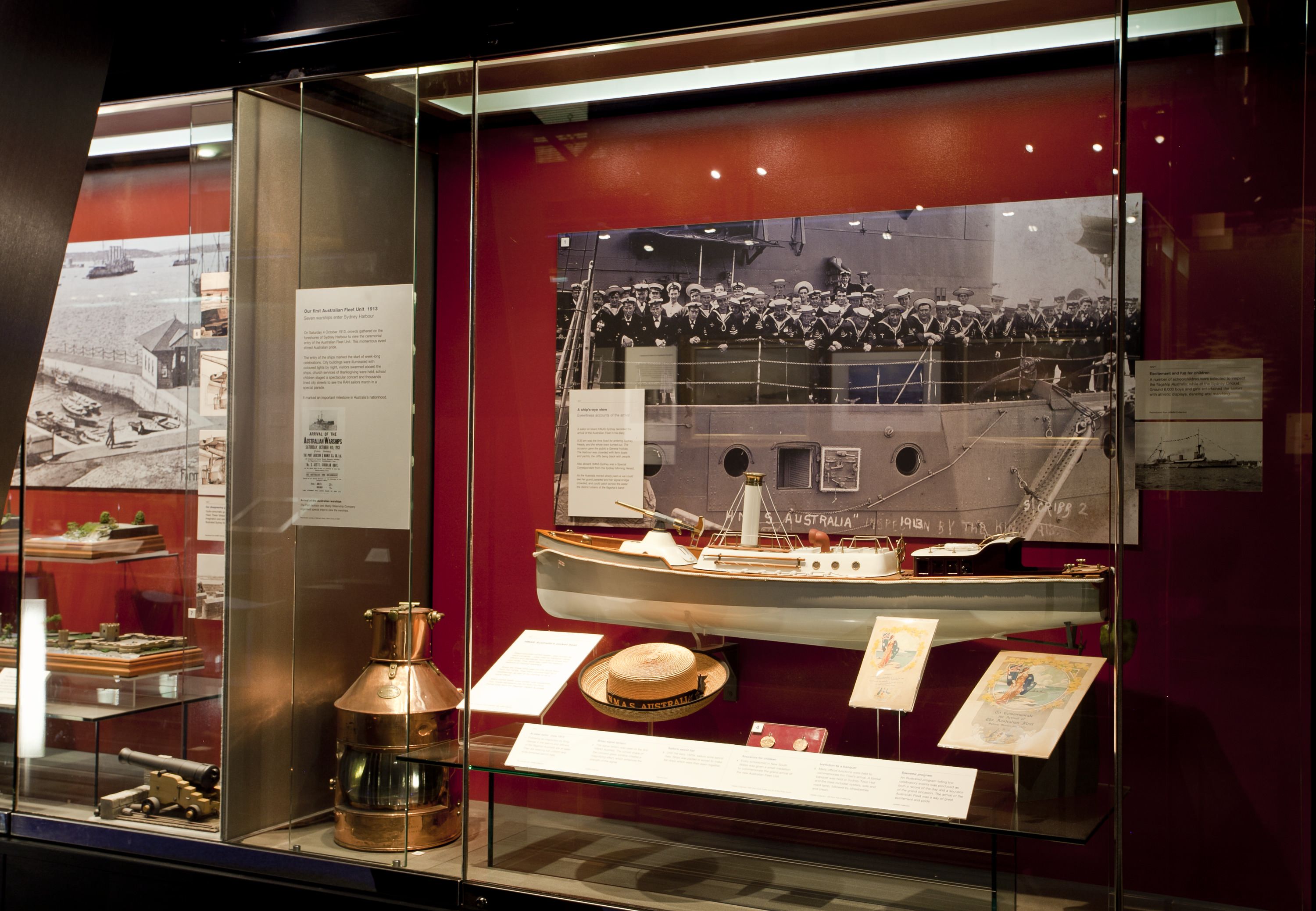 Photograph of a museum display case featuring objects and photographs.