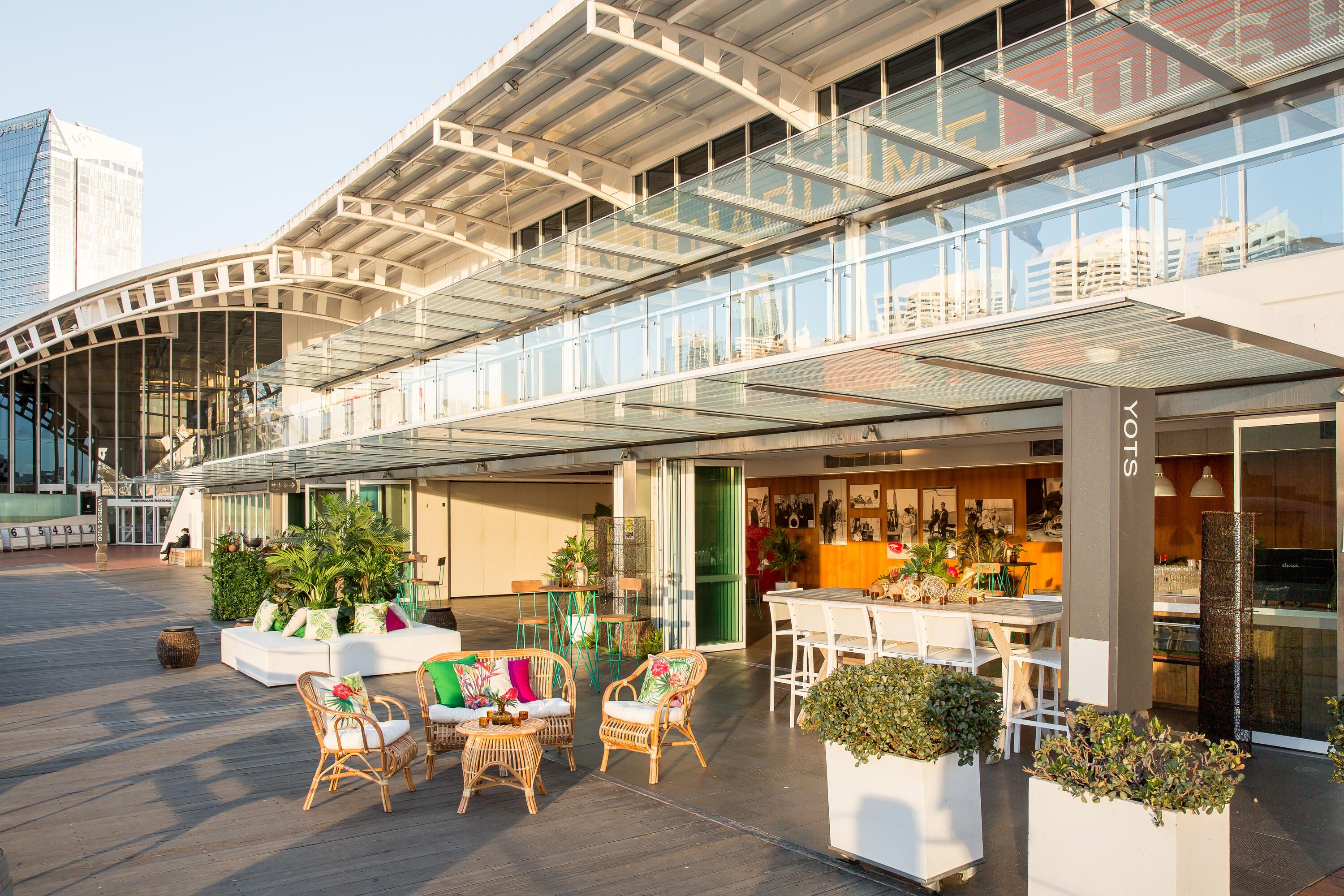 photo of an indoor outdoor space with event furniture and plants on a sunny day