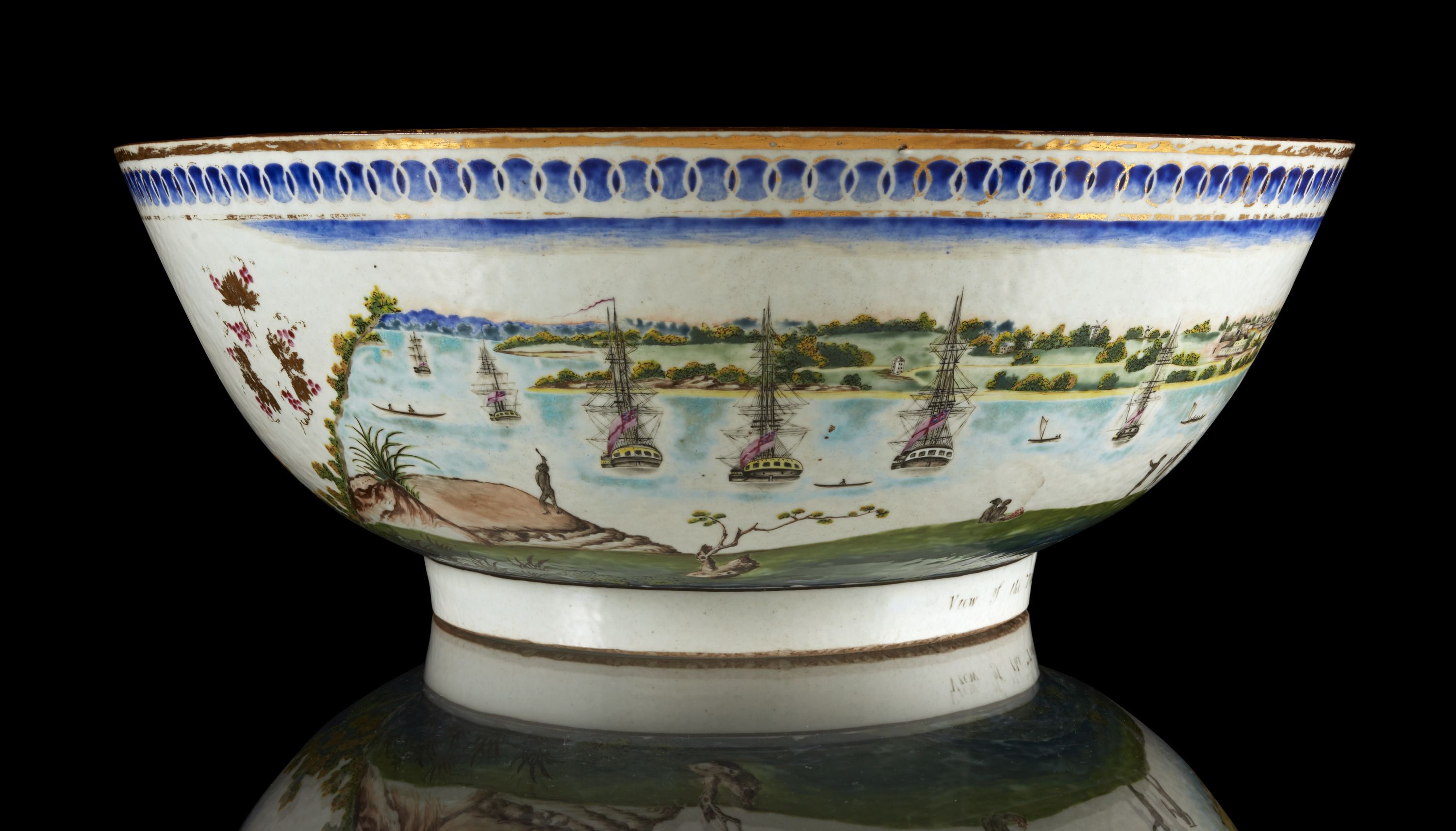 Photo of a painted porcelain bowl showing boats on a harbour. 