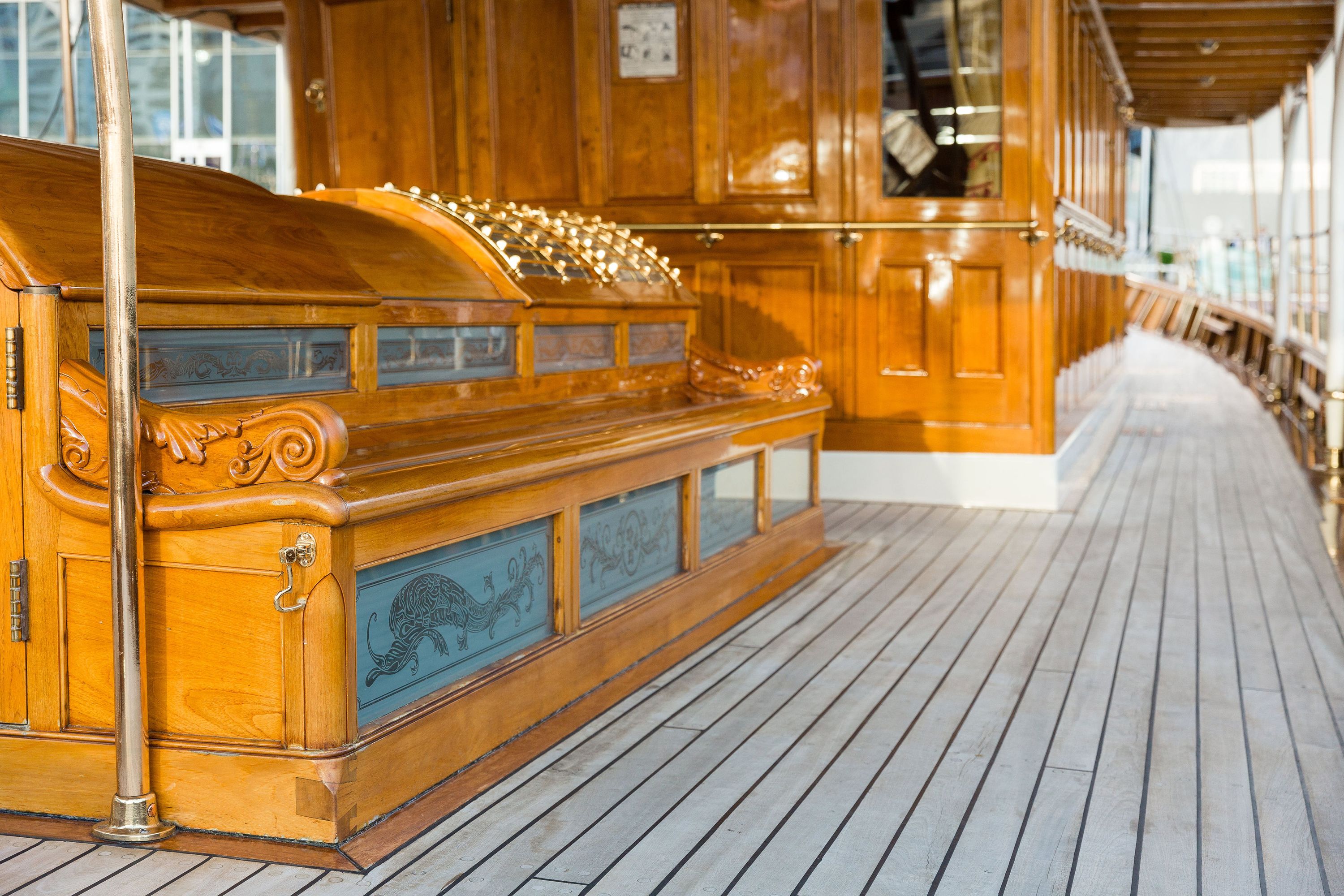 Photo of an Edwarding steam yacht showing detail of the vessel's deck, wooden seating and decorative glass skylights.