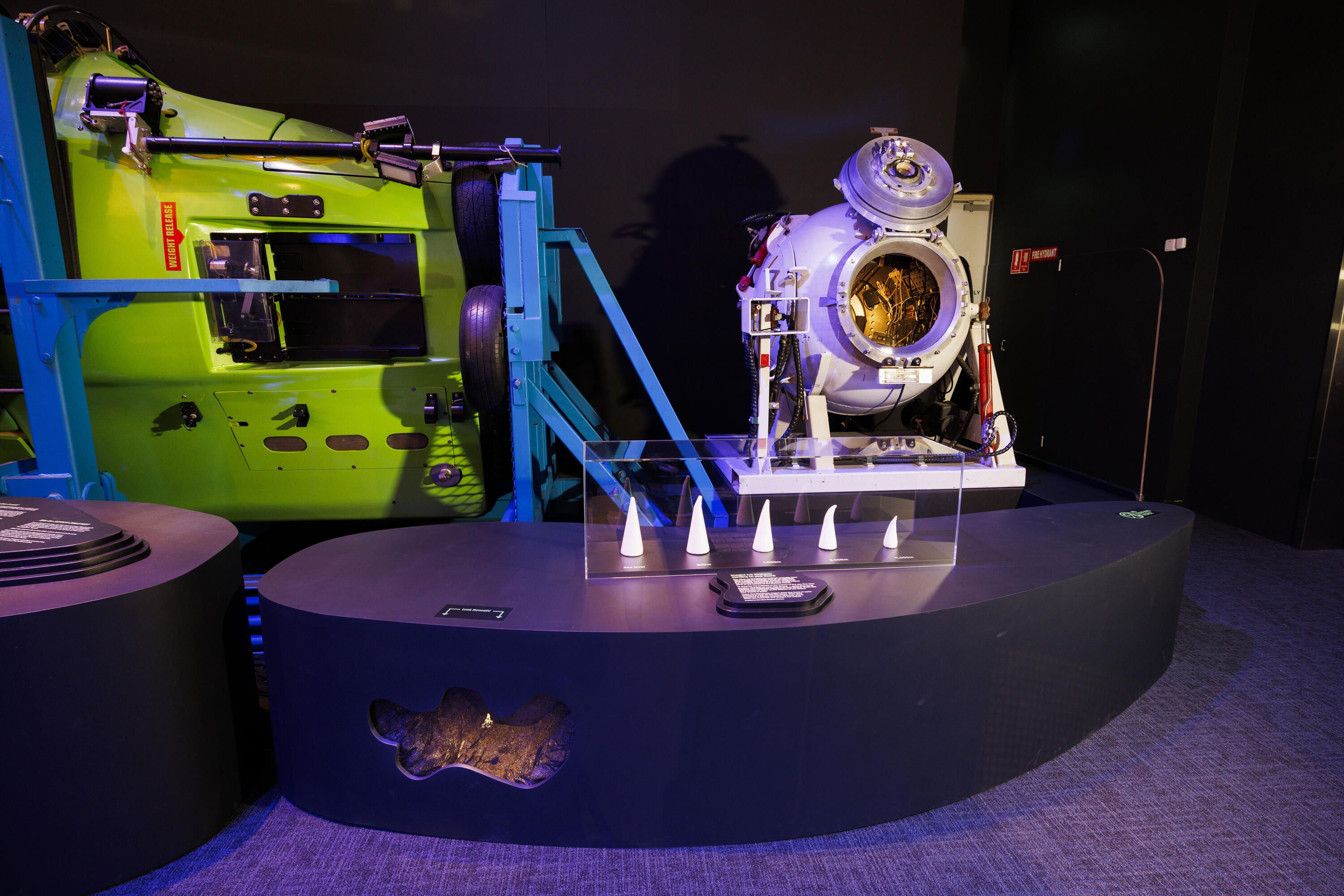 Photo showing part of a lime green submarine and a white sphere with a door to show inside.