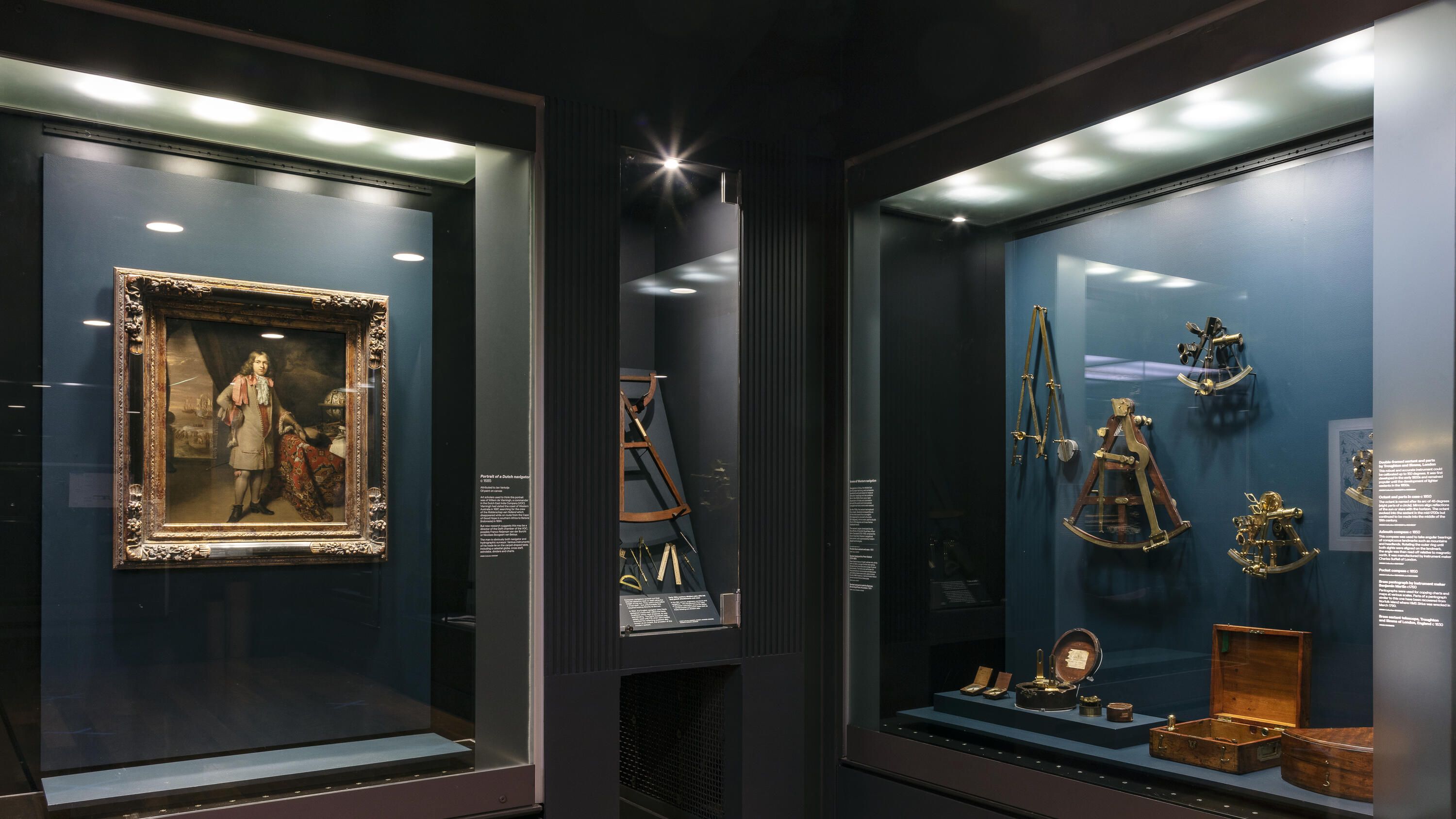 Photo shouwing museum gallery, with a framed painting in the display to the left and various navigatoral equiptment in the case to the right.