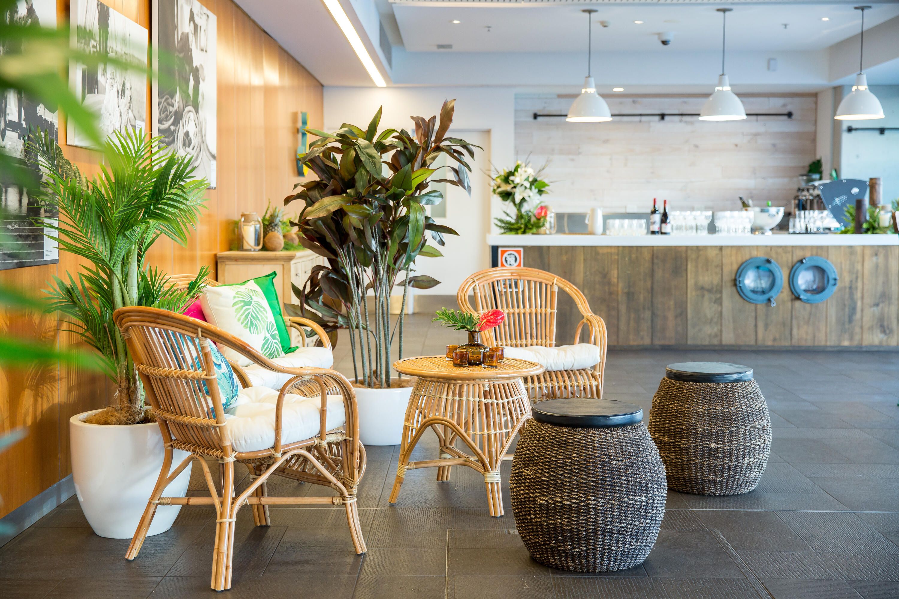 Photo showing an indoor space with plants, decorations and furniture in a coastal style.