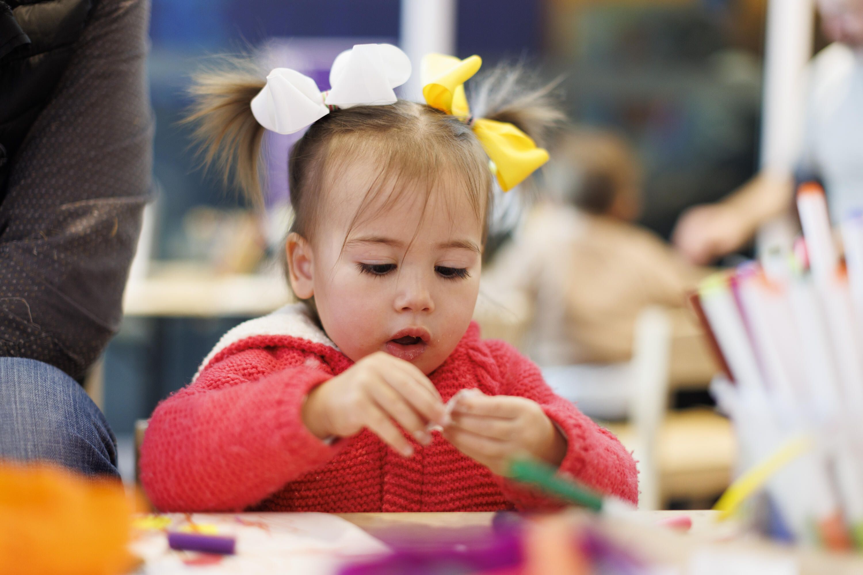 A photo of Little girl getting creative in the studio with Dad / carer.