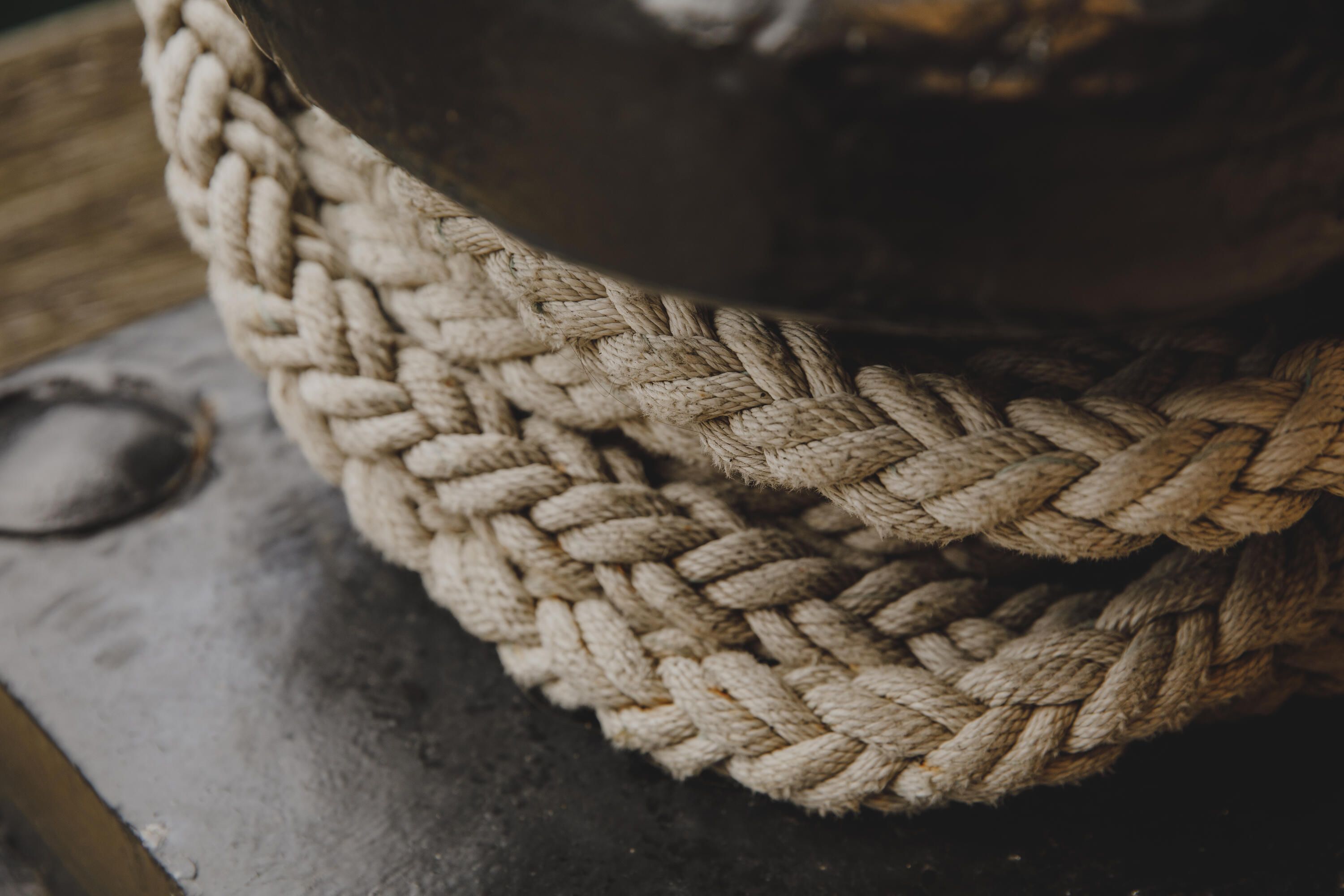 Photo showing a thick rope wrapped around a metal bollard