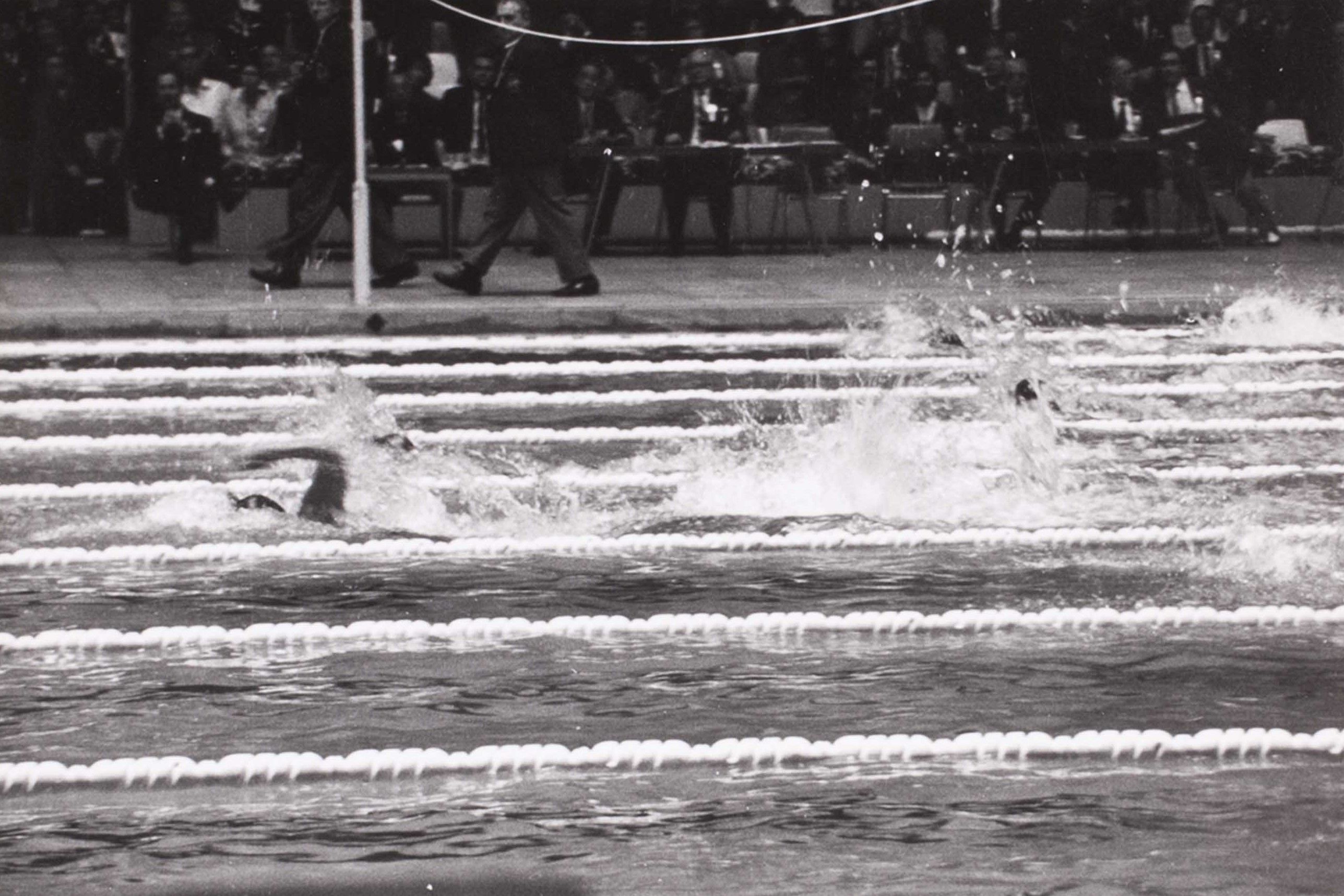 Black and white photo of a person swimming in a pool