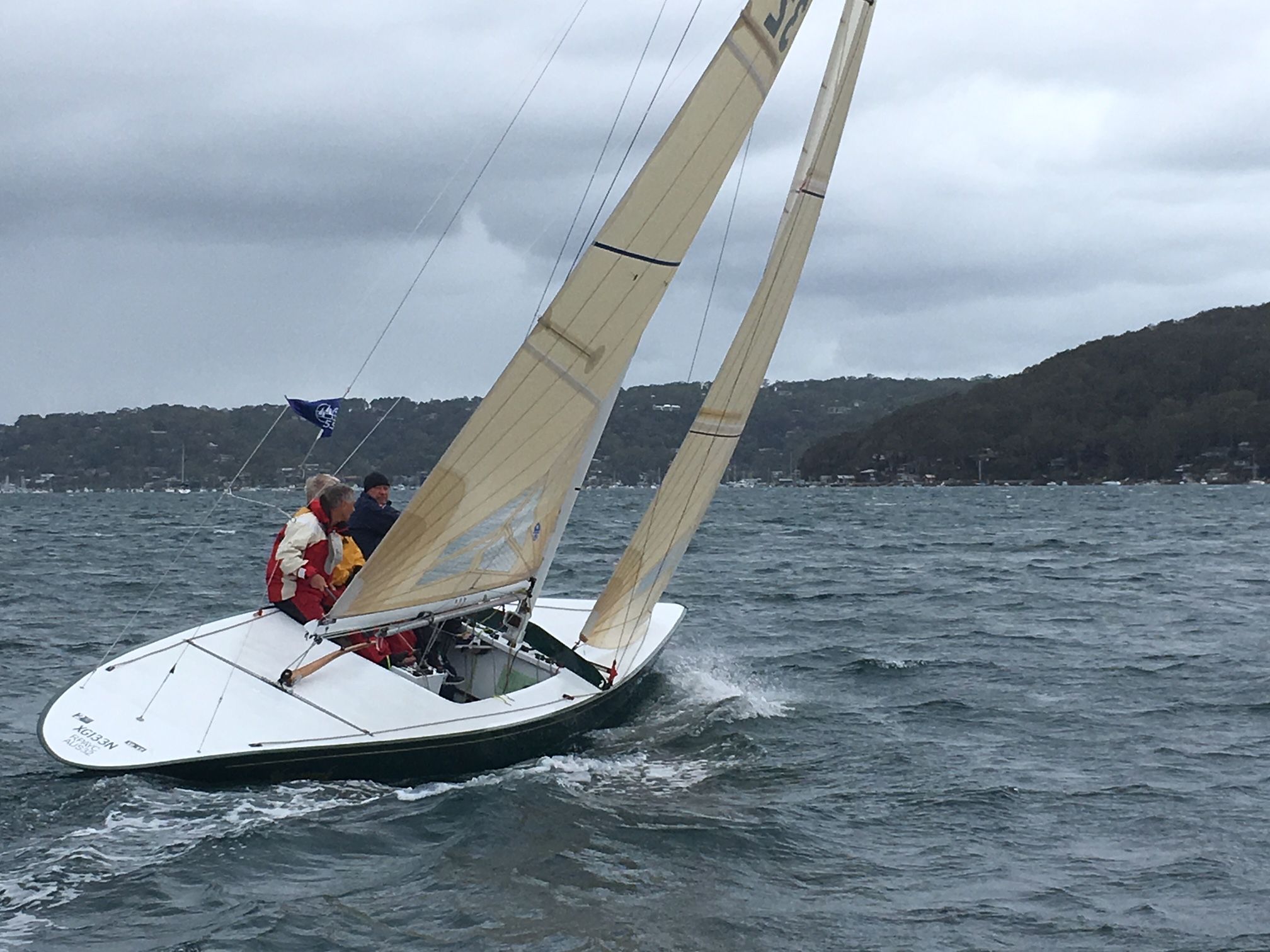 Photo of a sailing boat leaning into the wind.  
