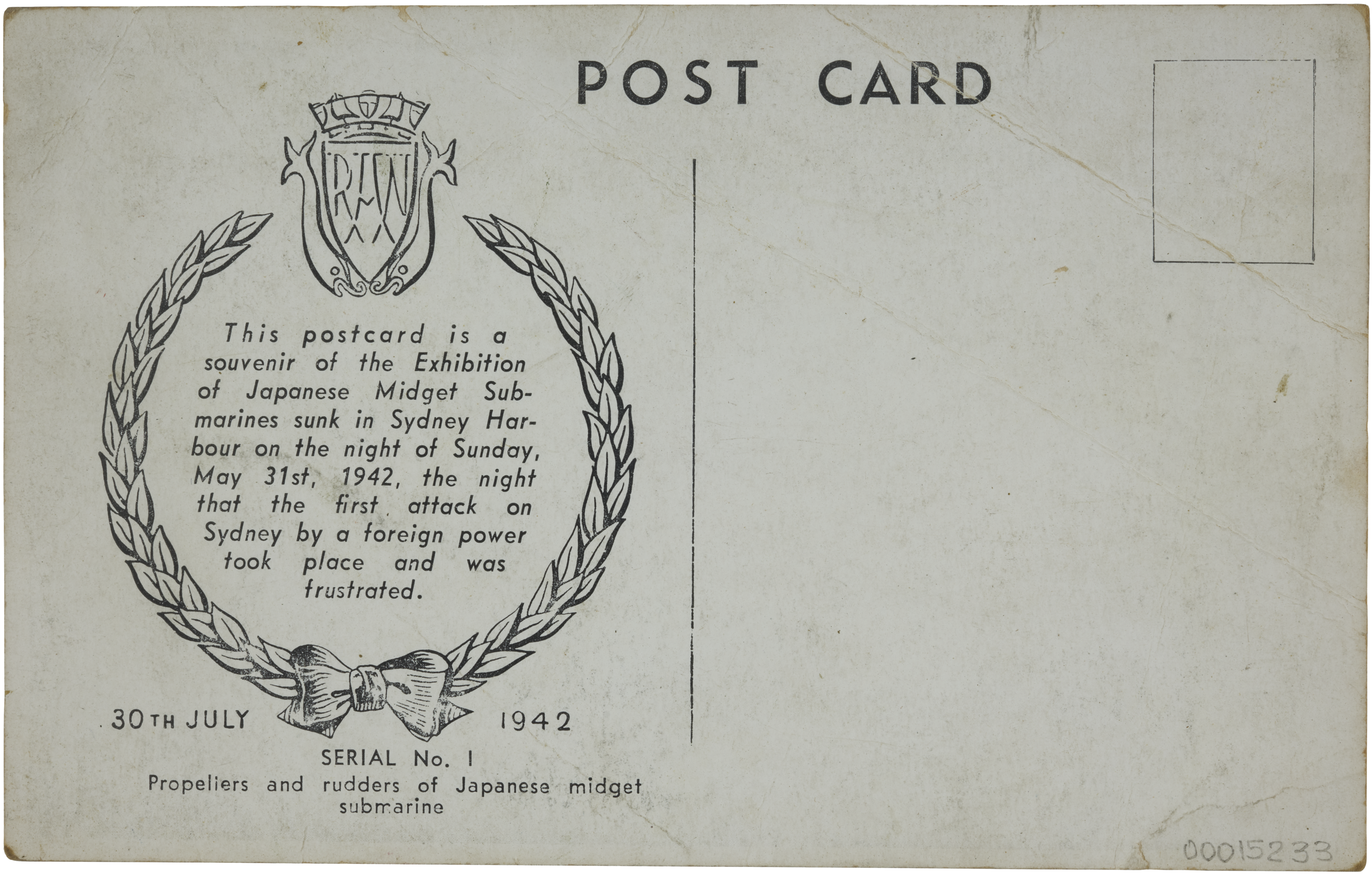 Reverse side of postcard with hand writing and a wreath