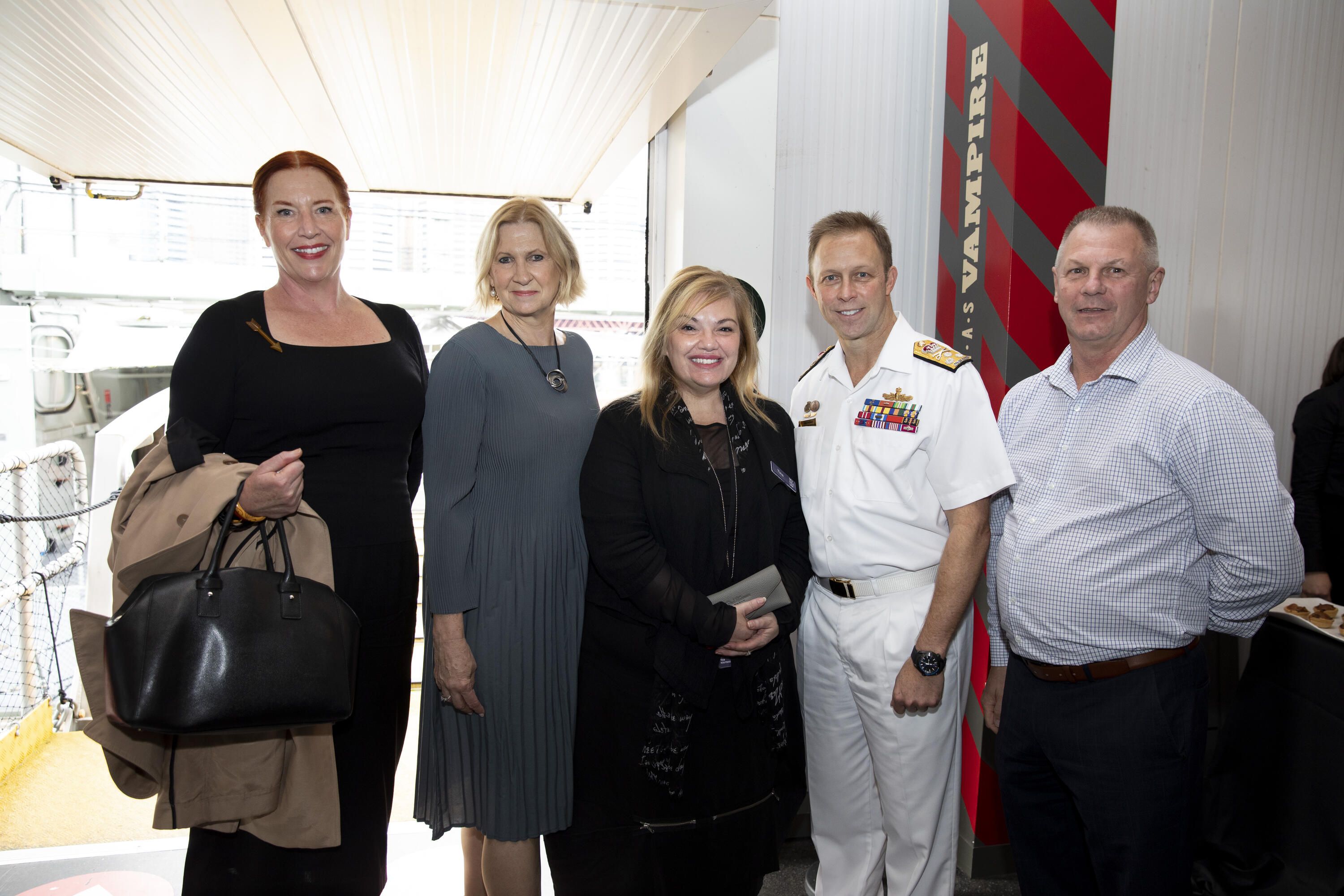 Photo of a group of peopl, some are museum staff, with Mike Noonan, Chief of Navy Australia.