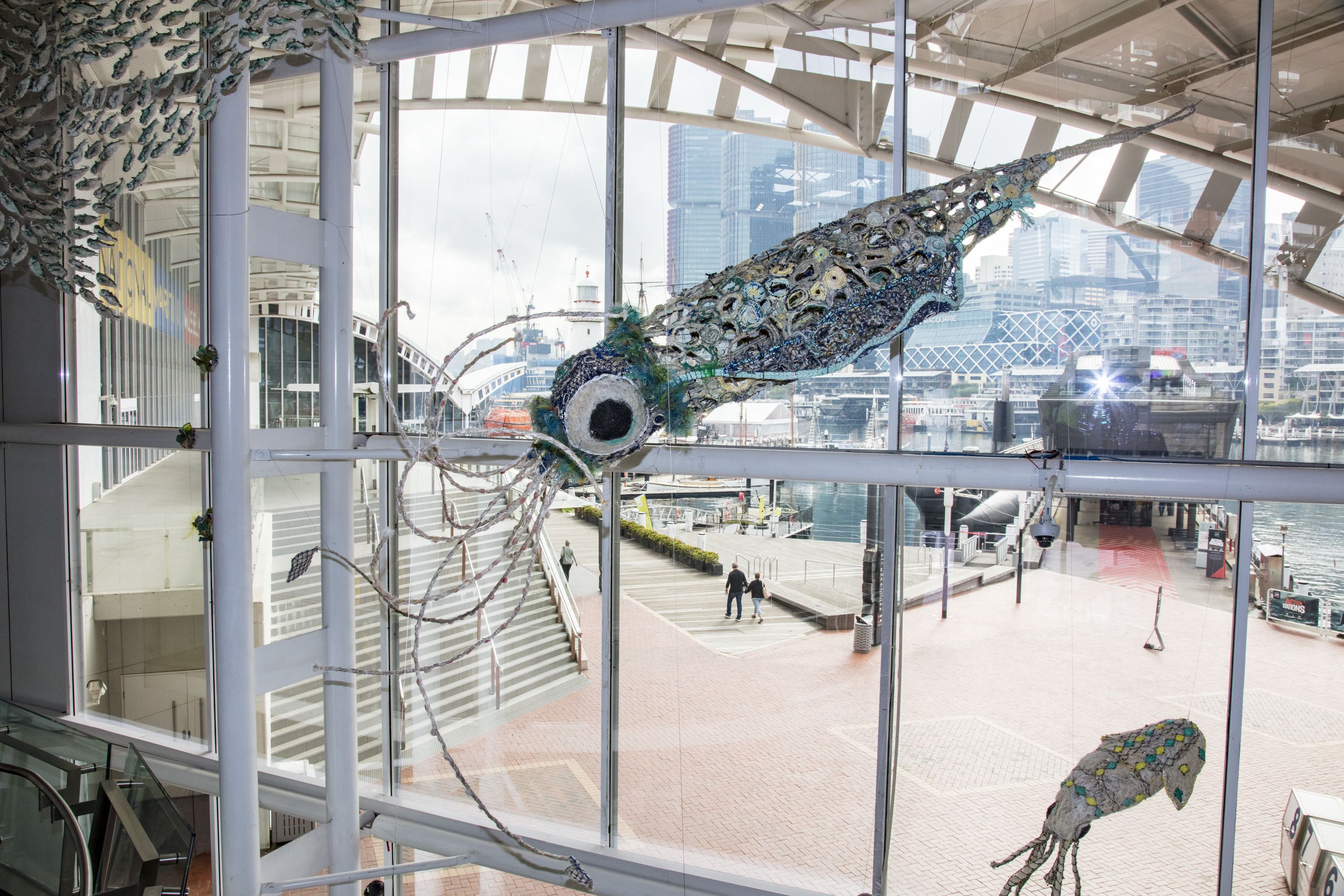 A large squid sculpture is shown in final position above the museum's foyer.