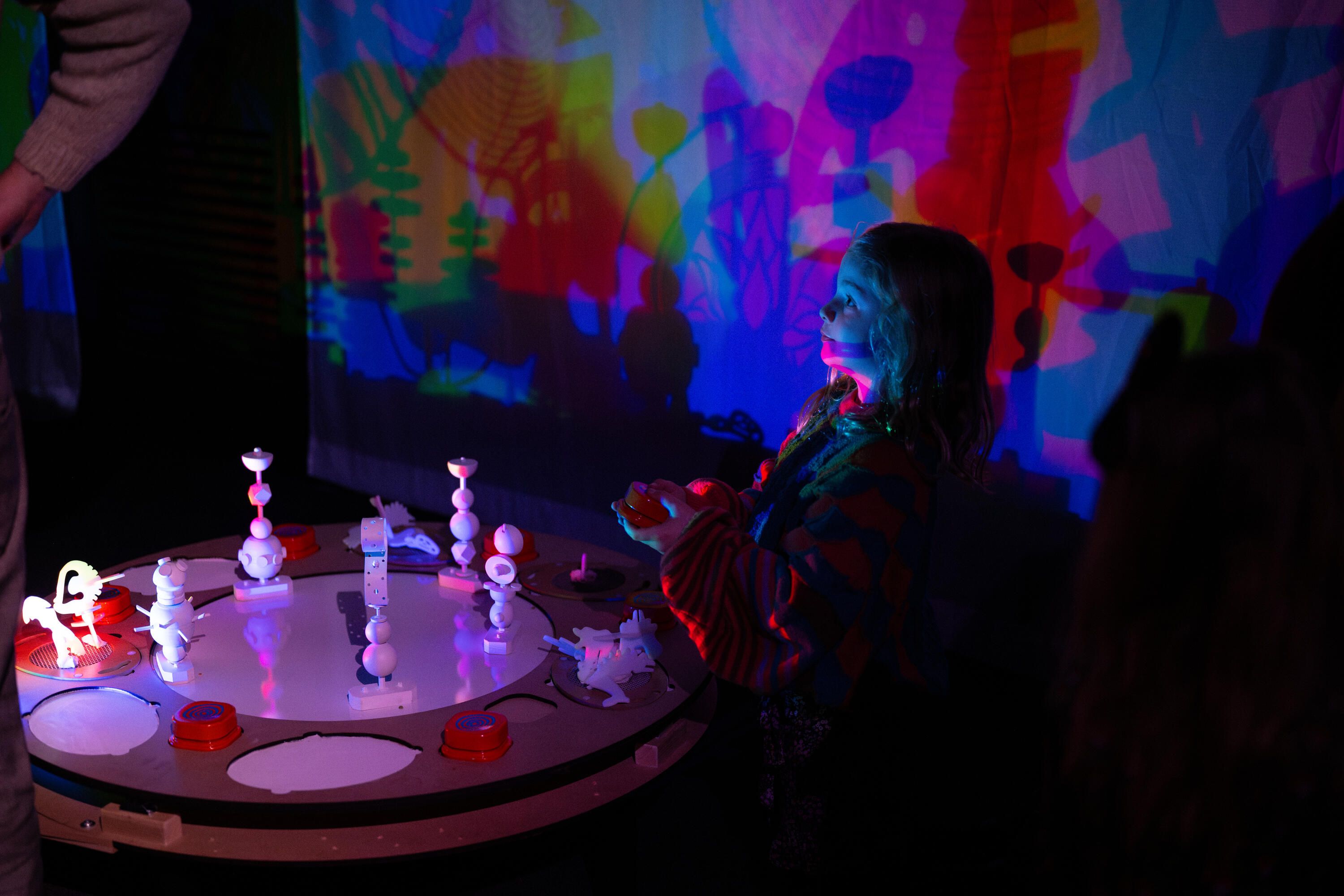 Child with coloured lights and a table of props
