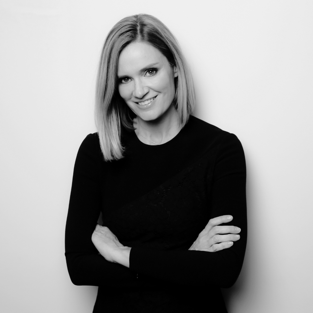 Black and white photo of a woman with medium length hair and a dark top.