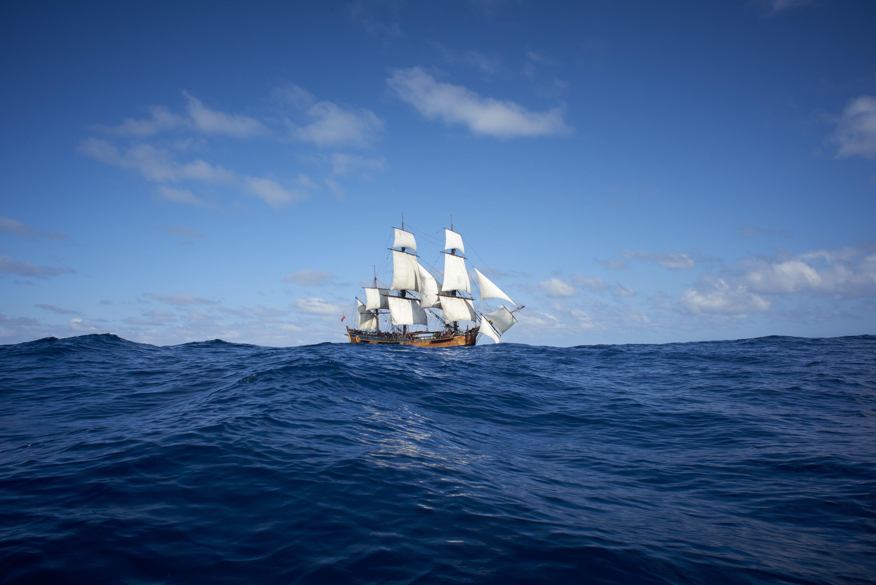 A tall ship, ENDEAVOUR under sail, at sea, blue skies. 