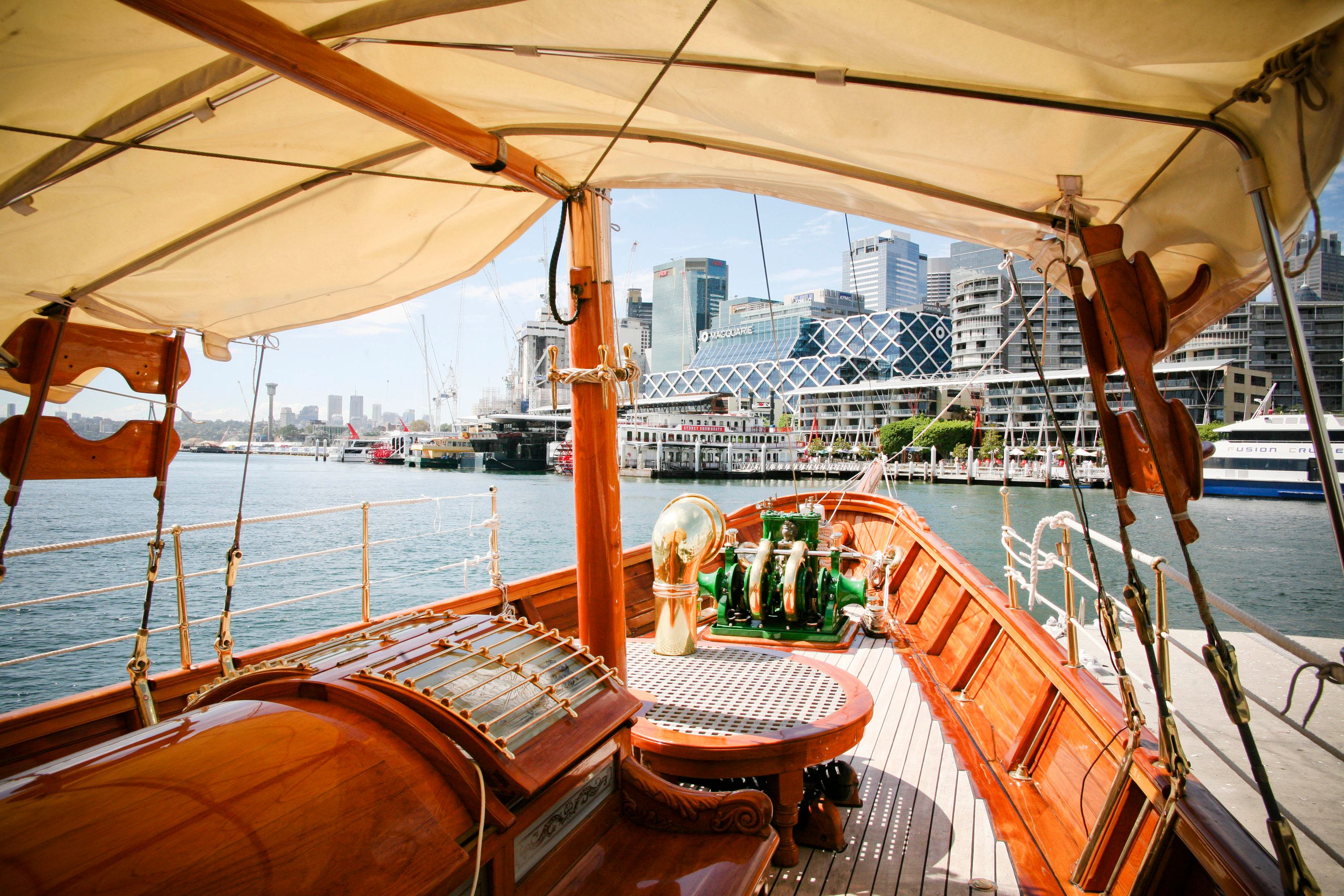 Photo showing the deck of a wooden steam yacht with a canvas awning above.