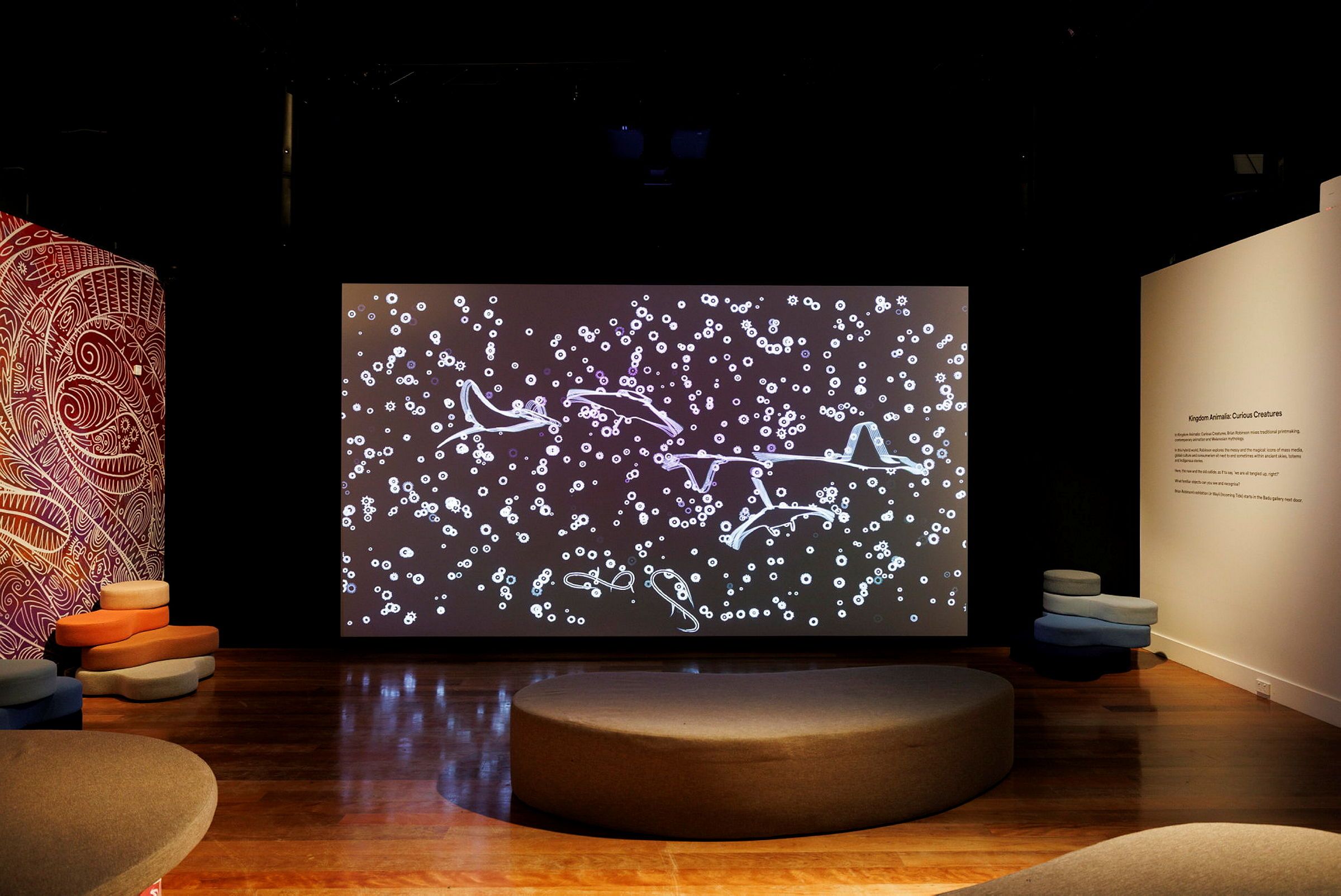 Photo of a museum exhibition display with a large screen.