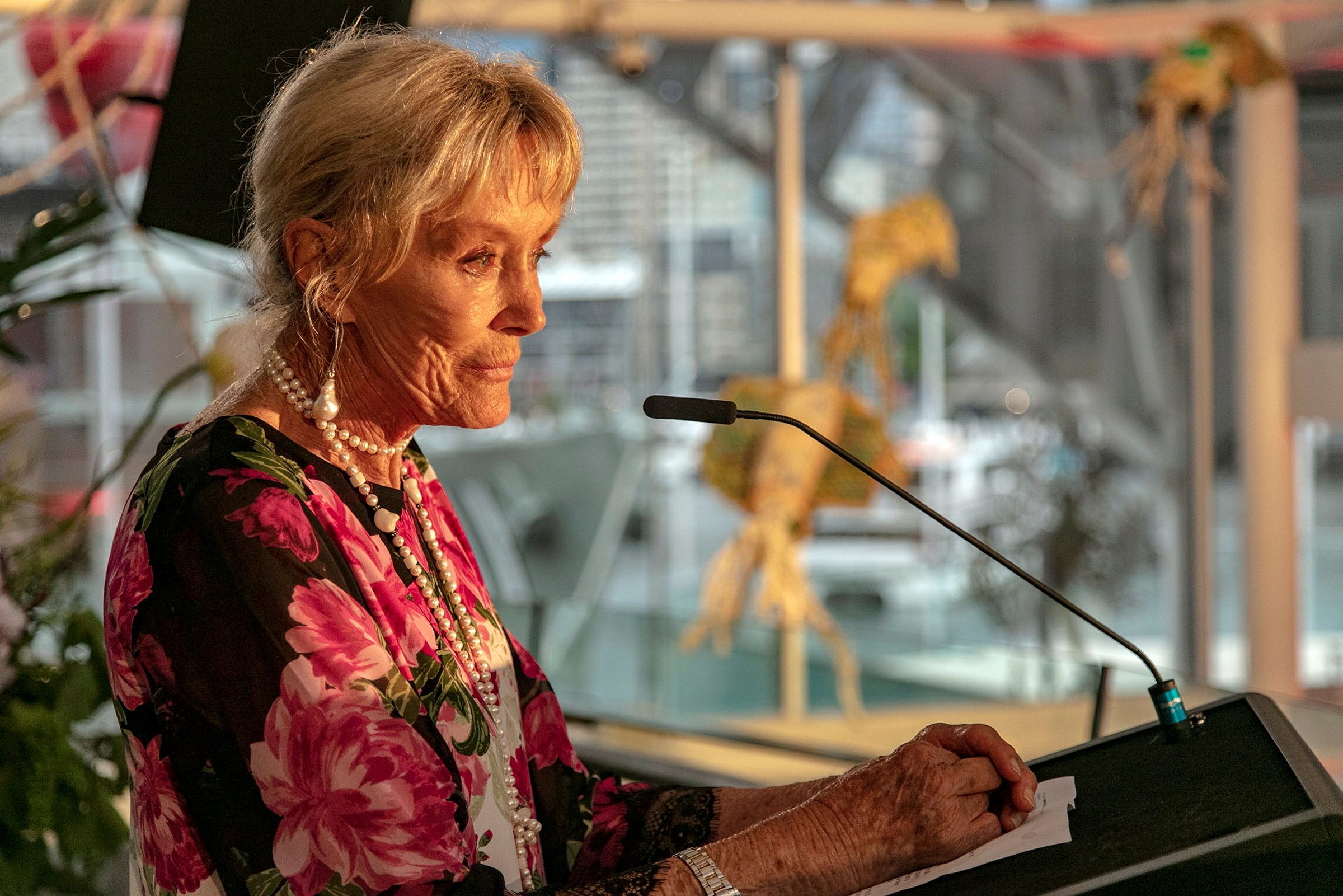 Photograph of an older woman speaking at a lecturn